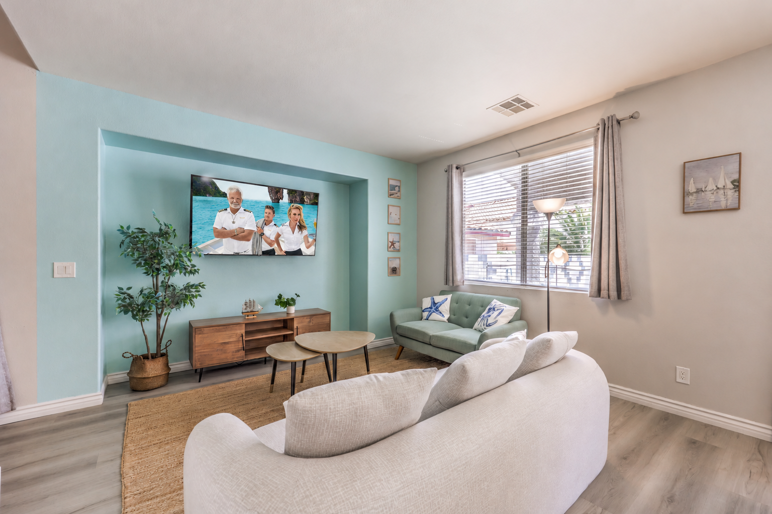 Bright coastal-style living room with TV, comfy seating, and natural light