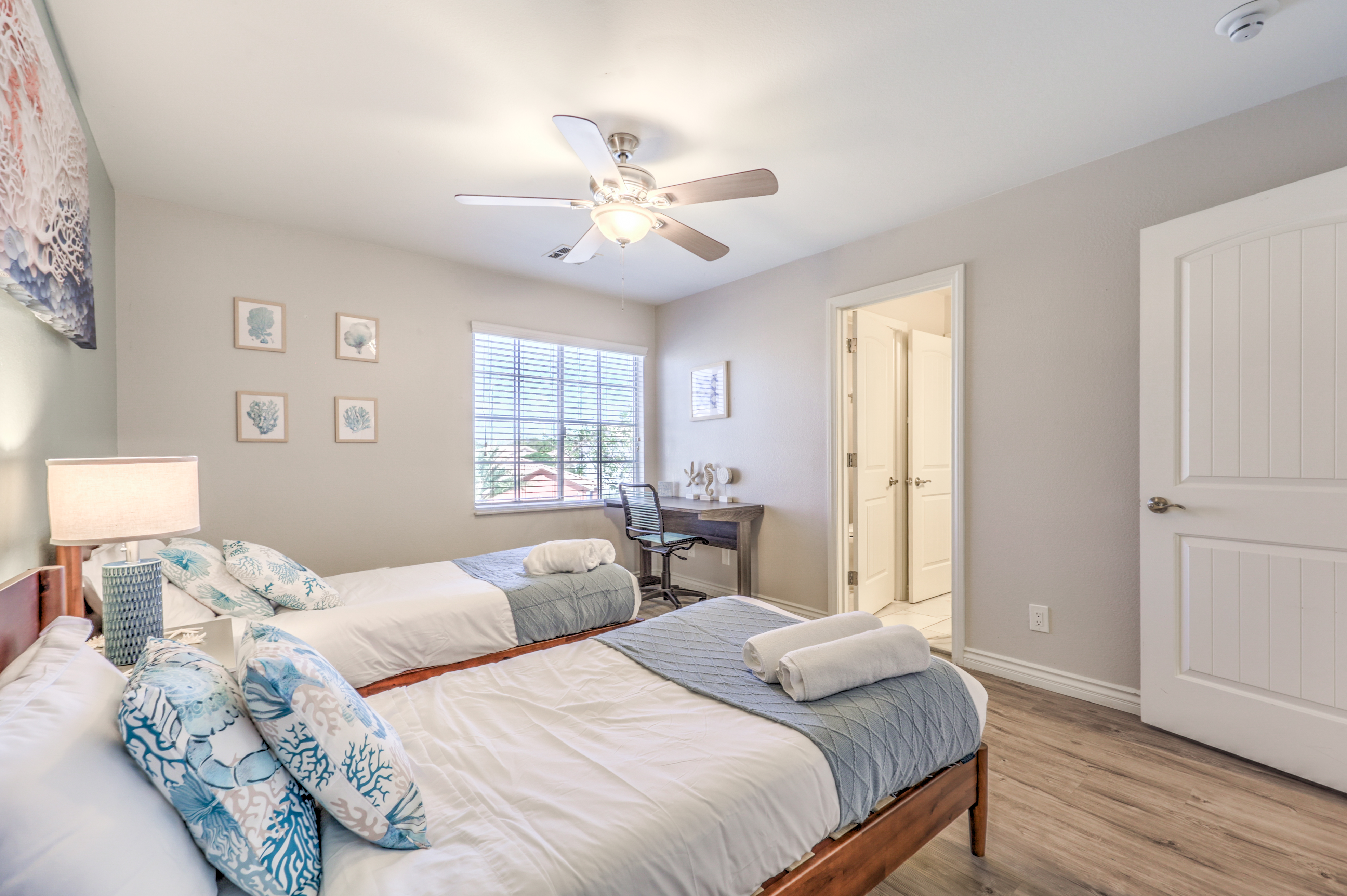 Bright double bedroom with workspace, natural light, and coastal style