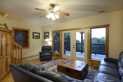 Cozy cabin-style living room with deck access and peaceful wooded views