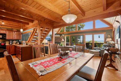 The whole main level is one open space, so whoever is cooking, whoever is setting the table and whoever is staring out the windows are all in the same conversation. The dining table seats eight, with room to pull up extra chairs for more.