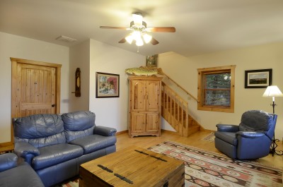 Cozy cabin-style living room with leather seating and warm wood accents