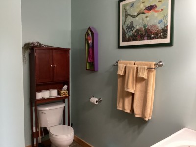 Charming bathroom with warm wood accents, plush towels, and smart storage