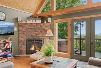 Claim the leather recliner by the stone fireplace, prop your feet on the ottoman and pick something from the shelf of books, puzzles and board games. The glass doors beside you open straight onto the deck when you want fresh mountain air.