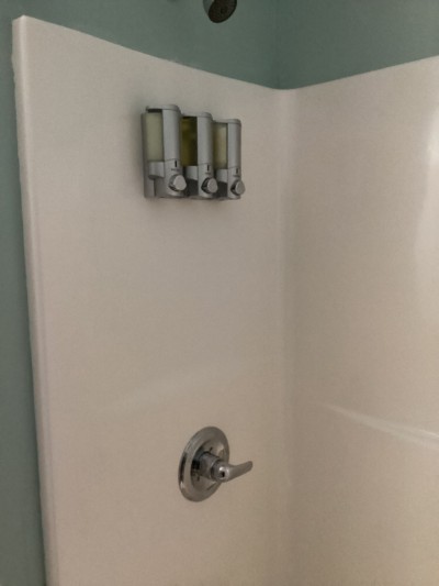 Bright walk-in shower with modern fixtures and built-in amenity dispensers