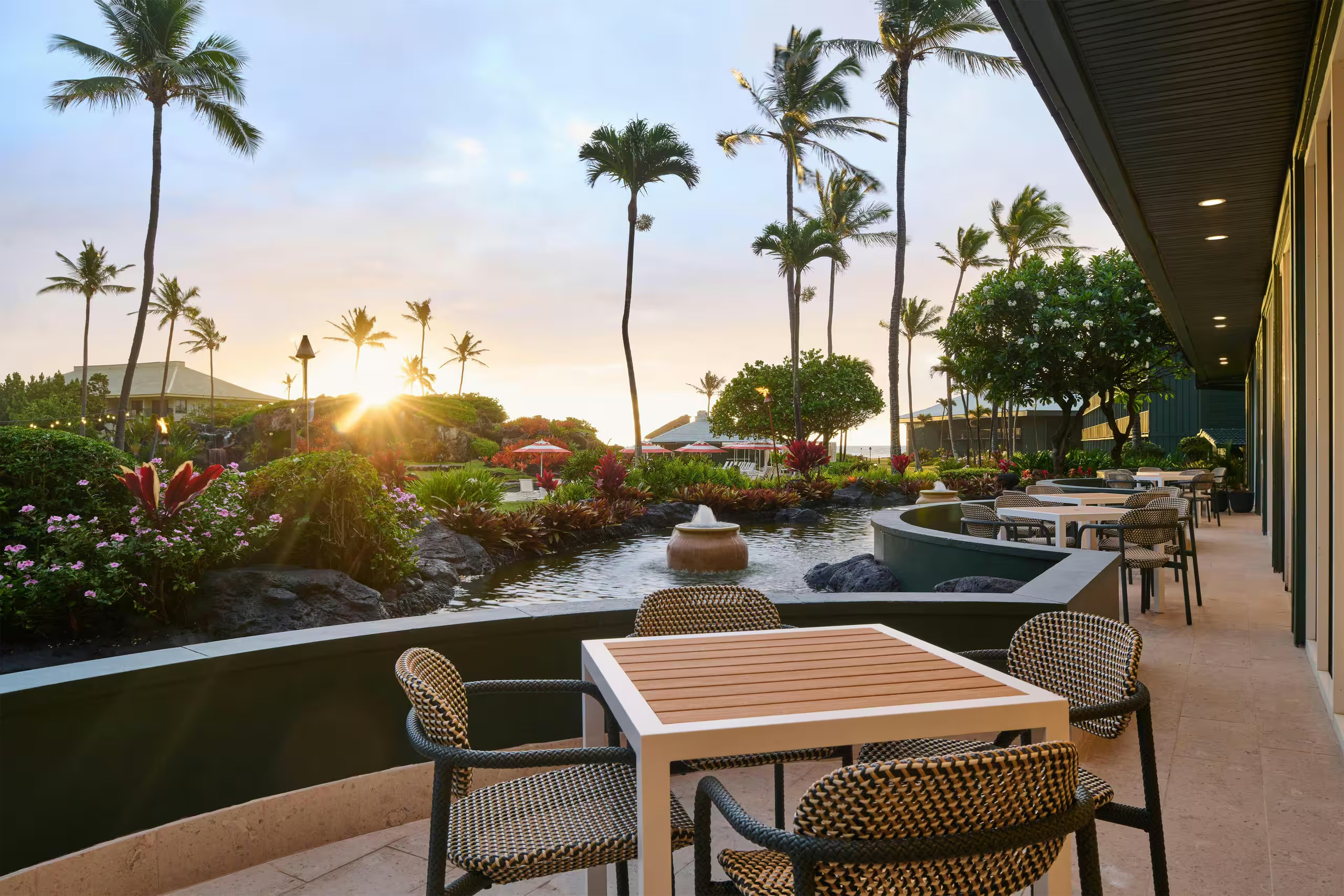 Sunset terrace dining with tropical gardens and a tranquil water feature at Ocean House