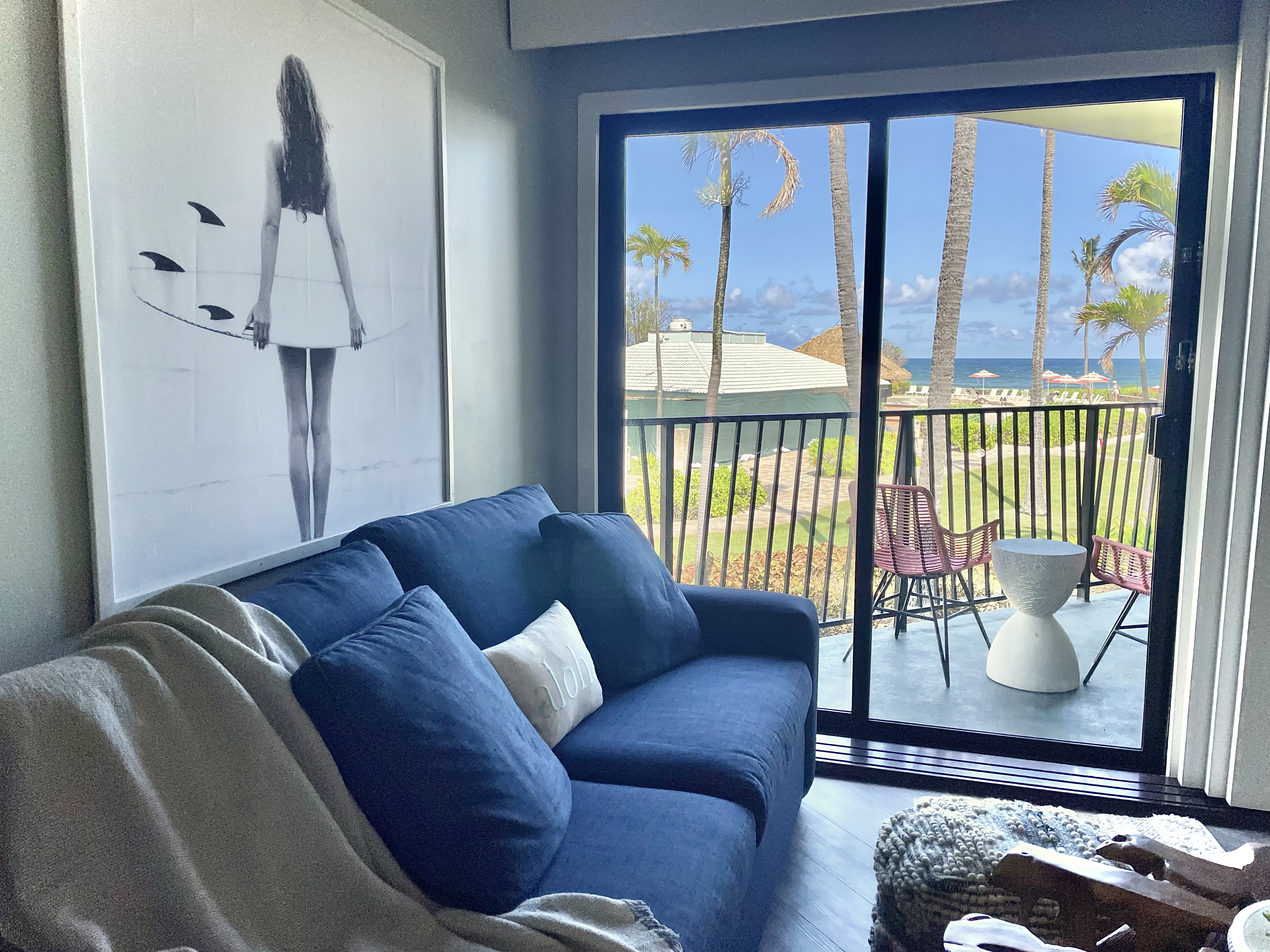 Cozy coastal lounge with private balcony, palms, and ocean views