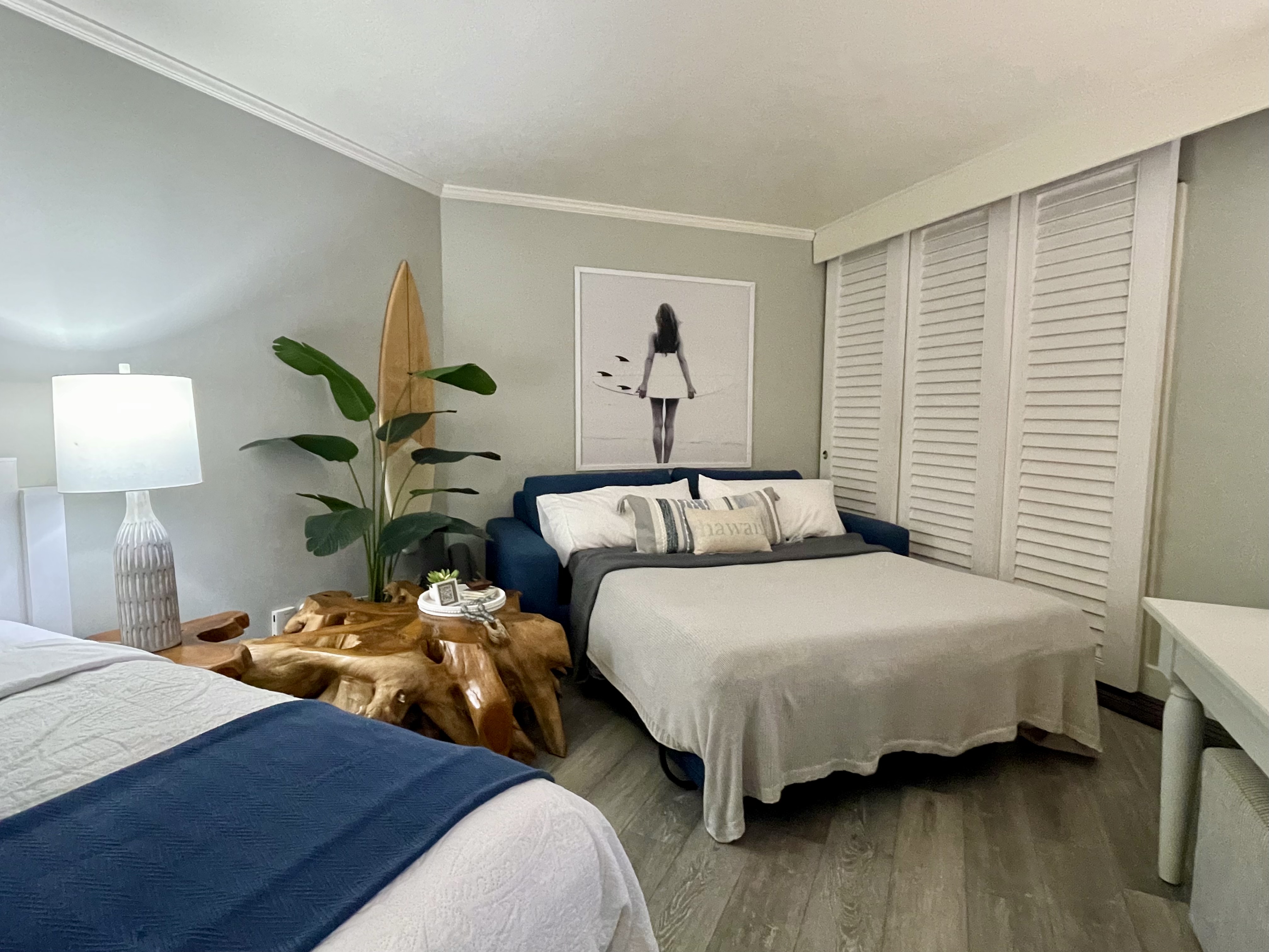Coastal-inspired bedroom with two beds, stylish decor, and ability to sleep 4