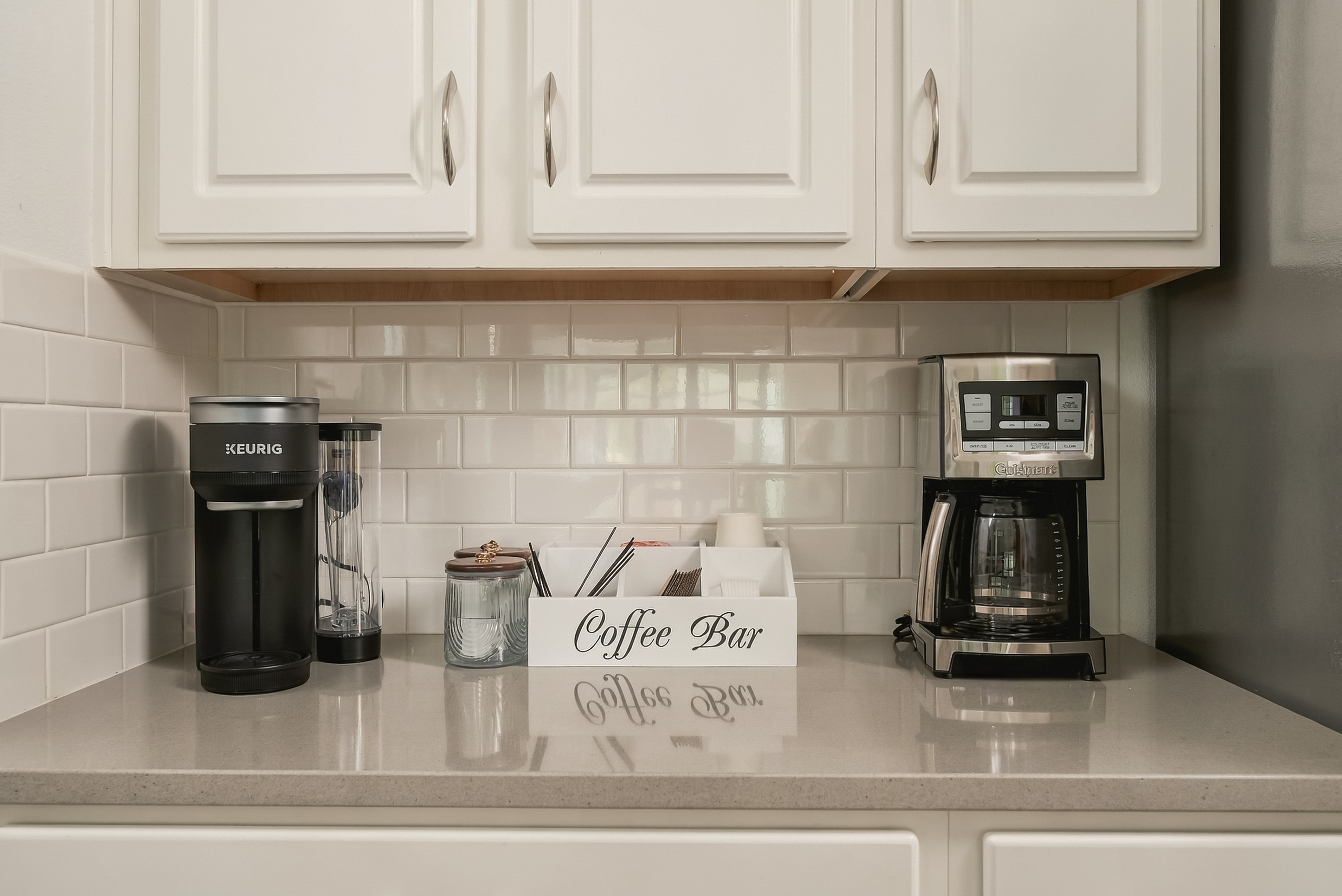 Bright kitchen coffee bar with Keurig, drip maker, and stocked essentials