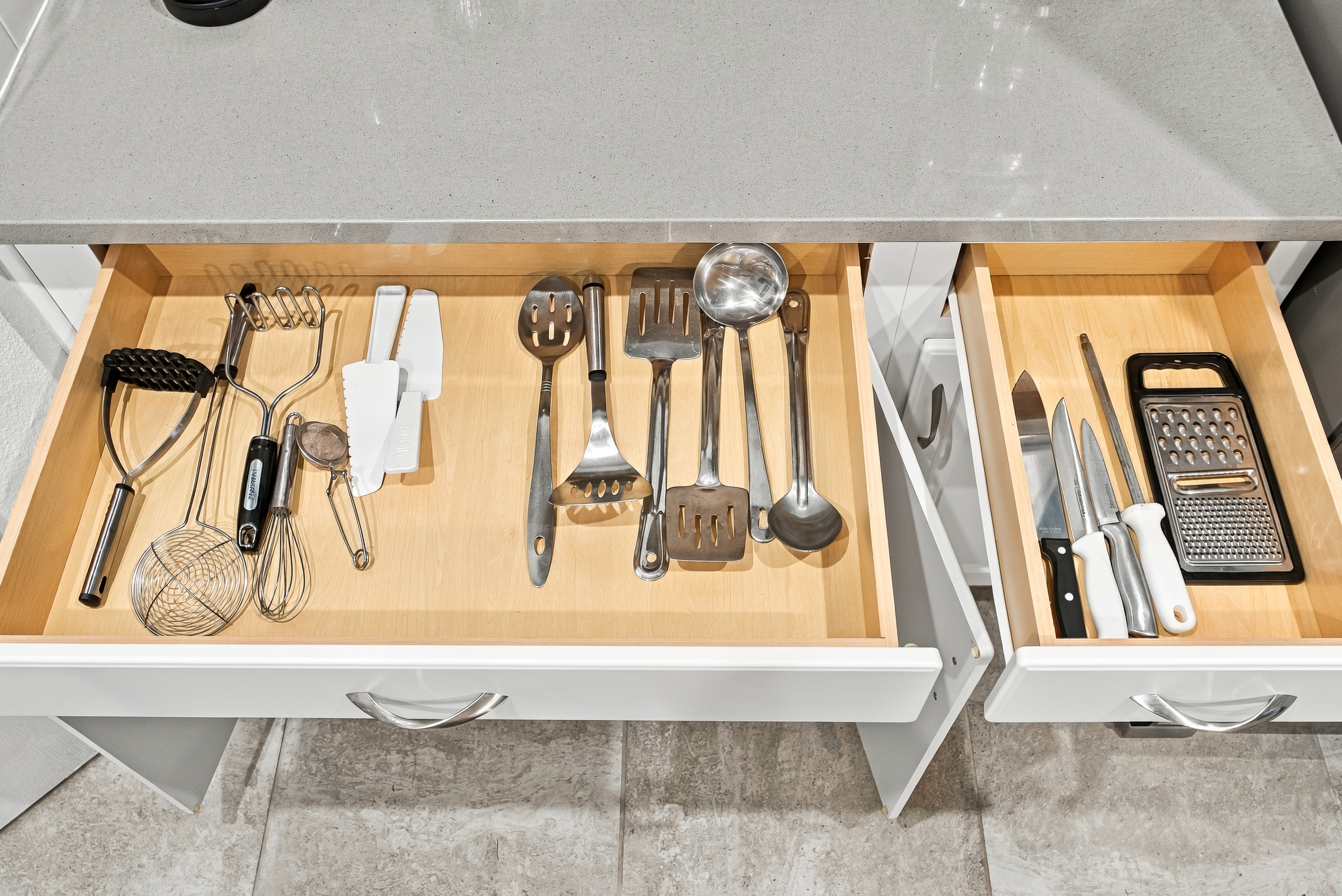 Fully stocked kitchen drawers with organized cooking tools and cutlery