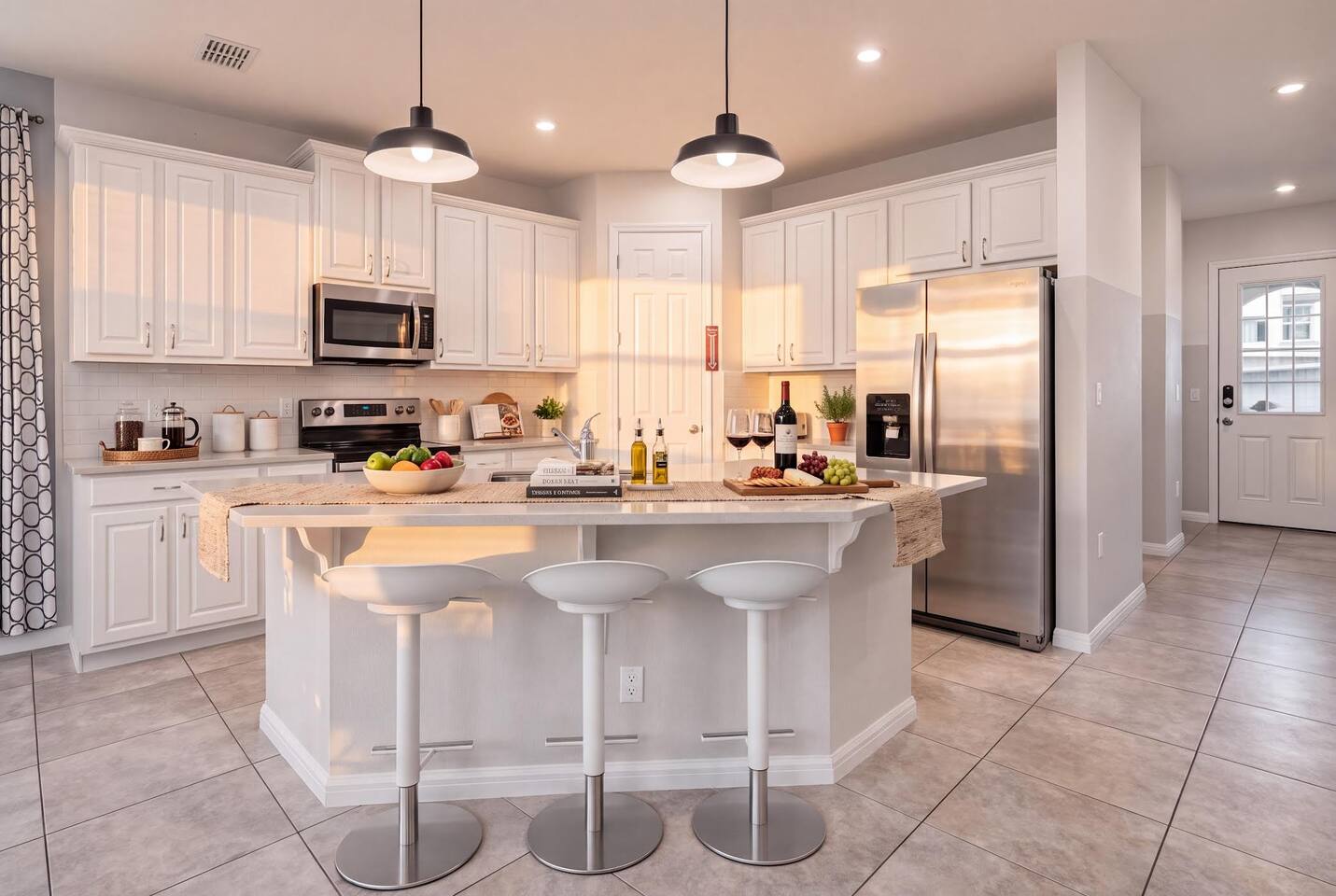 A bright, fully equipped kitchen with full-size stainless appliances, stone countertops, and an island with seating for five. Stocked with cookware and full place settings for the whole group — everything you need to cook and gather.
