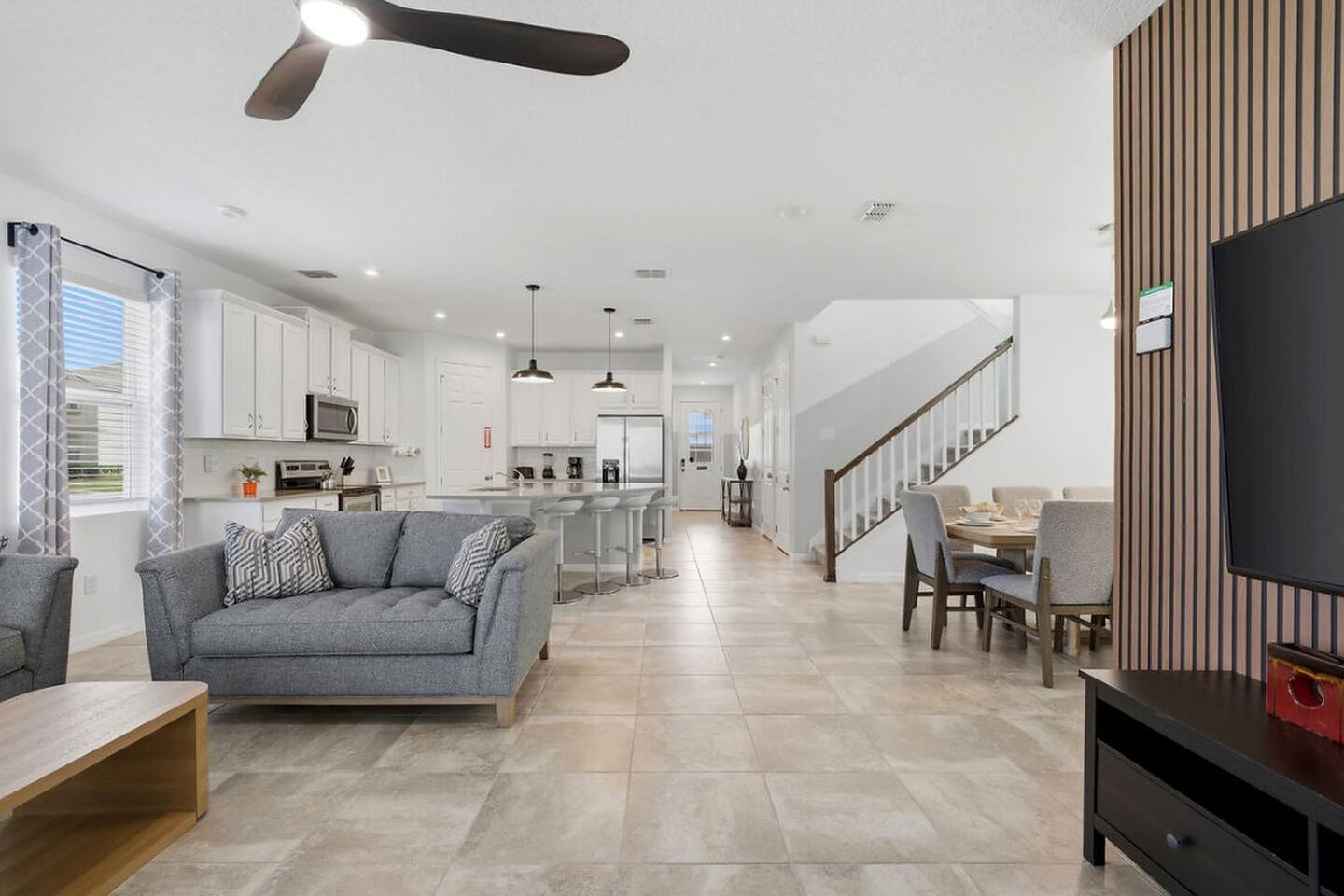 One connected, open-concept main floor — living room, kitchen island with seating, and dining table all flow together, so your whole group can relax, cook, and gather in the same bright space.