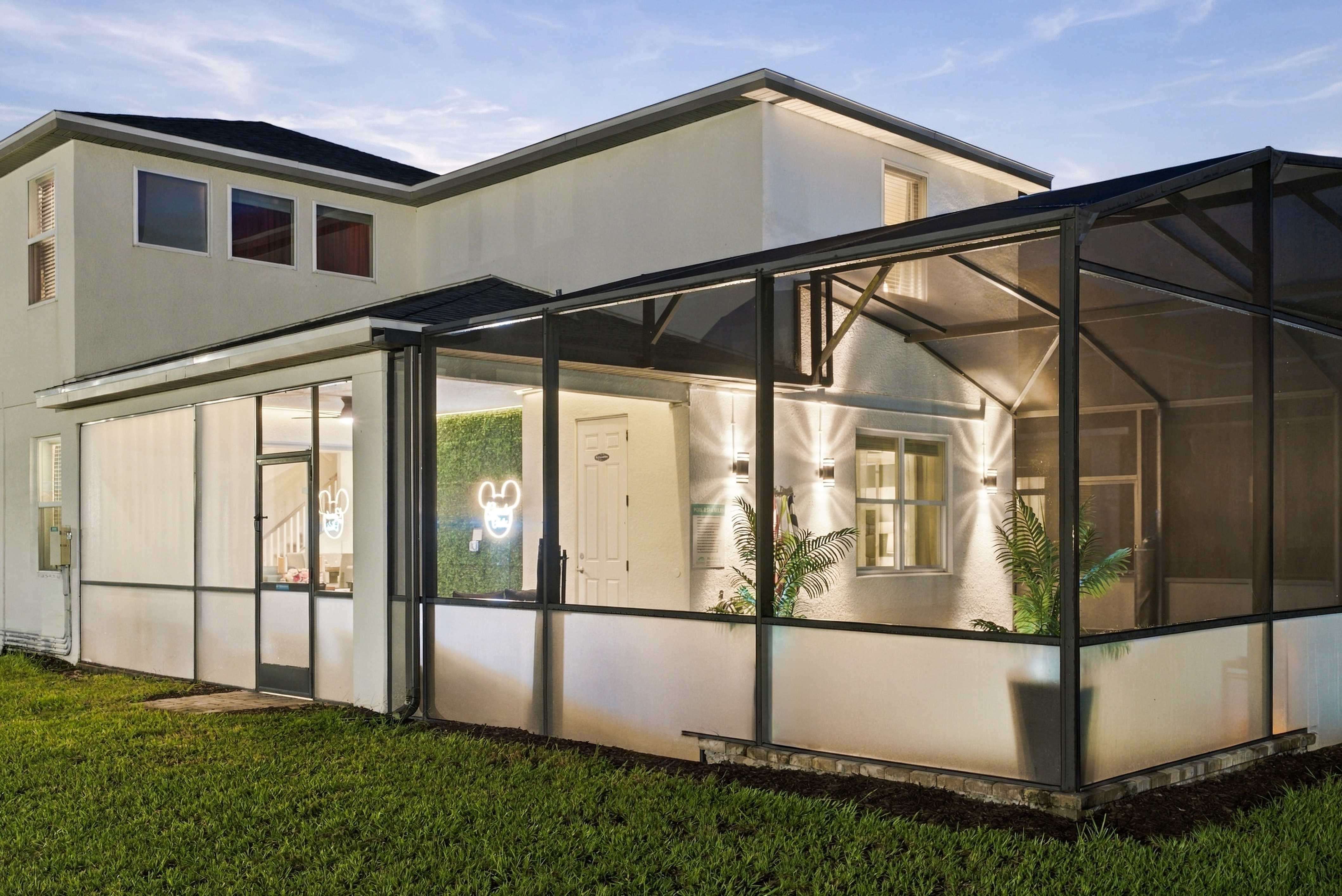 Spacious screened lanai with warm lighting and stylish outdoor ambiance