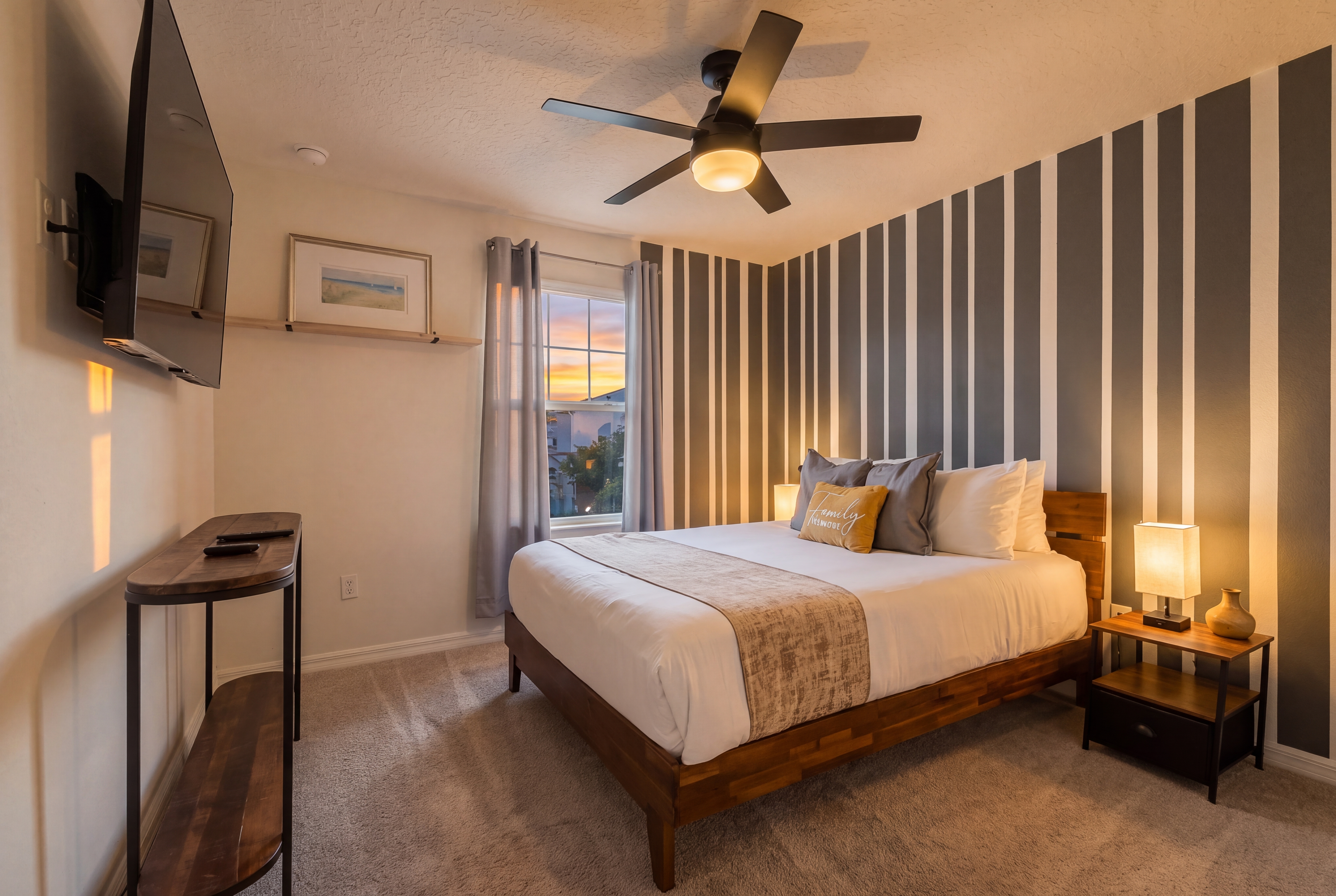 Bedroom 4- 2nd Floor Queen Bedroom. Stylish sunset-lit bedroom with TV, accent wall, and cozy modern touches in attached en-suite full bathroom with shower.