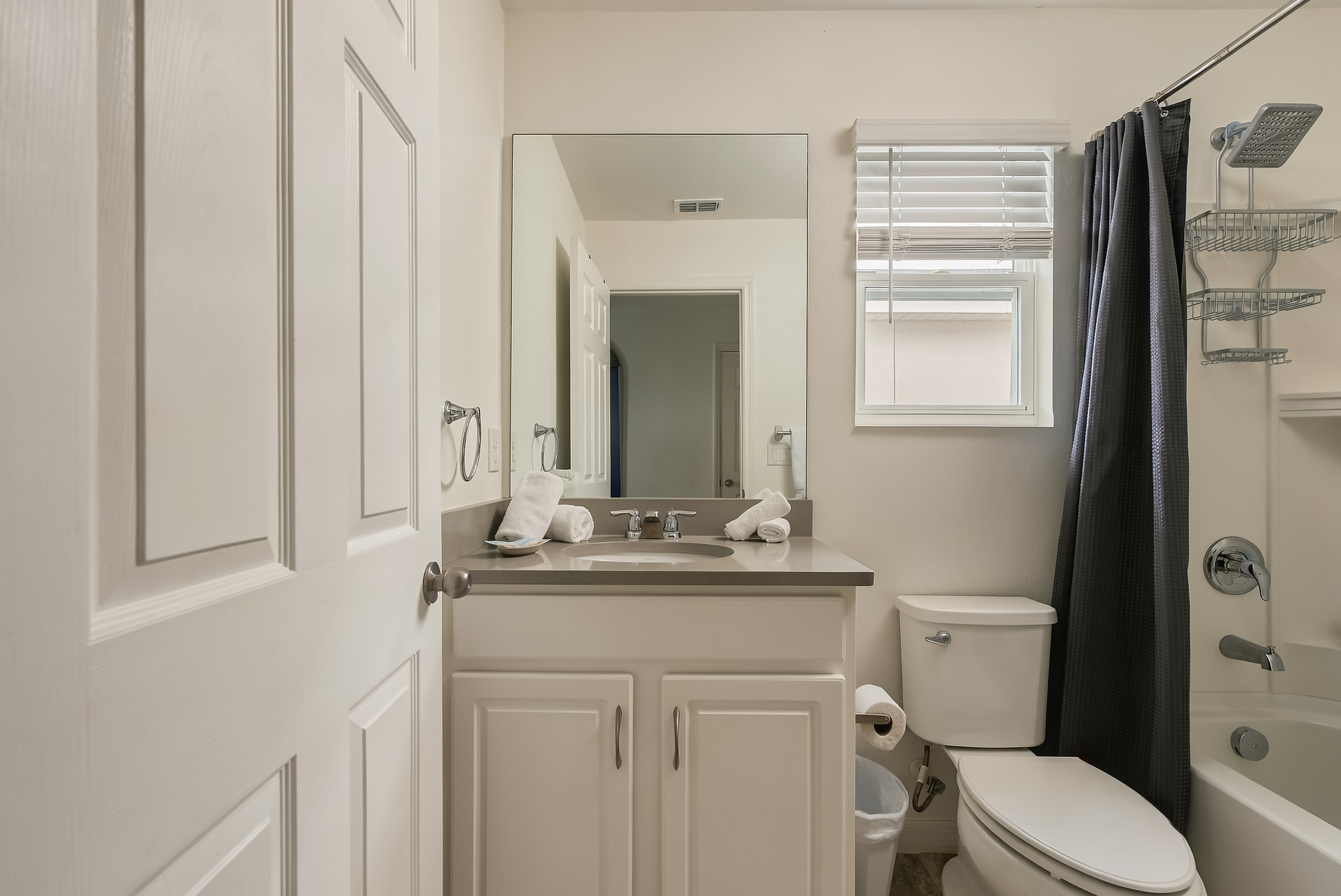 Bright, clean bathroom with tub-shower combo and natural light