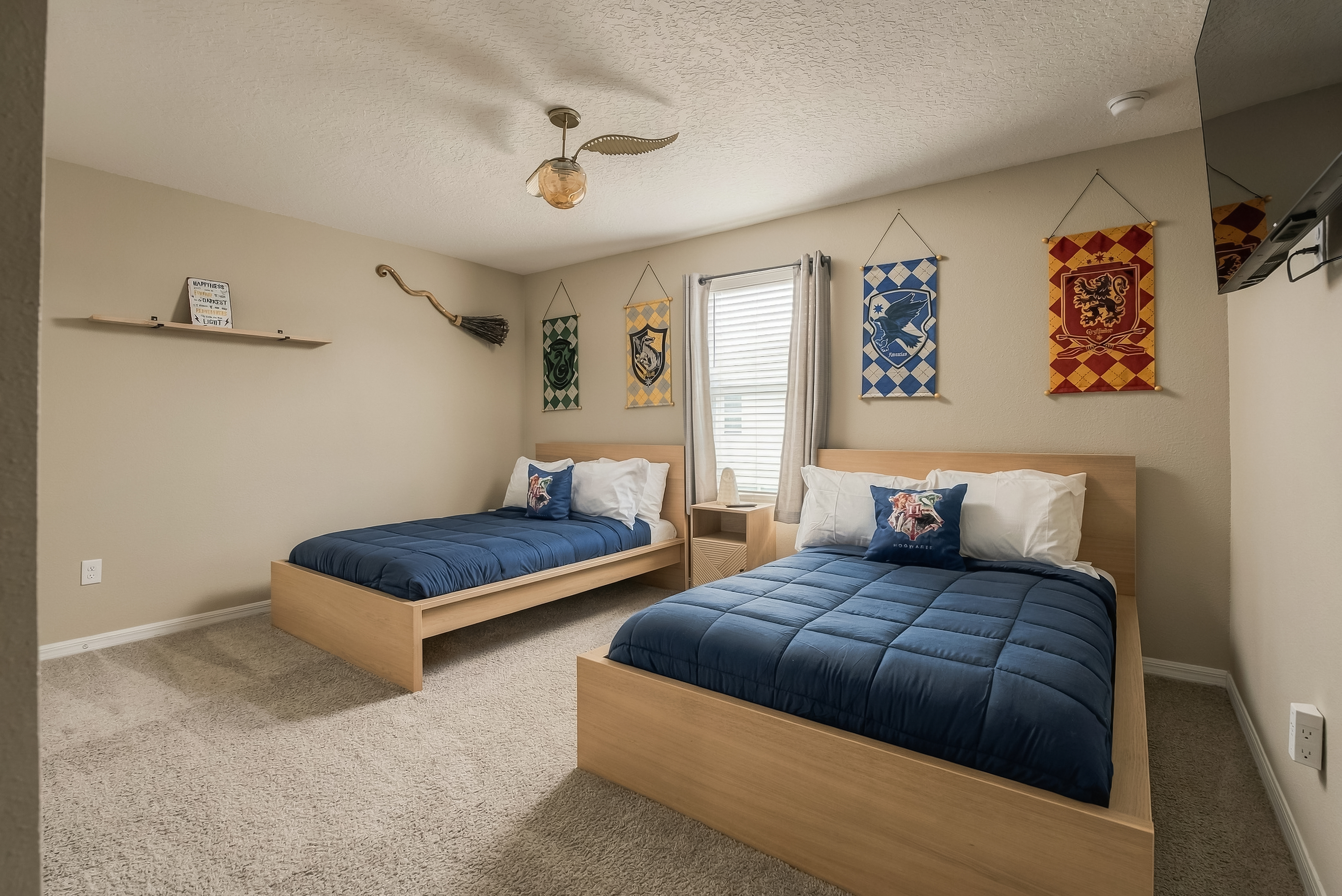 Bedroom 7 -The Wizard- Harry Potter themed room — two Full Size beds, house banners, and magical touches for the witches and wizards in your group.  Framed wizard house-crest banners on the walls, and themed décor.
