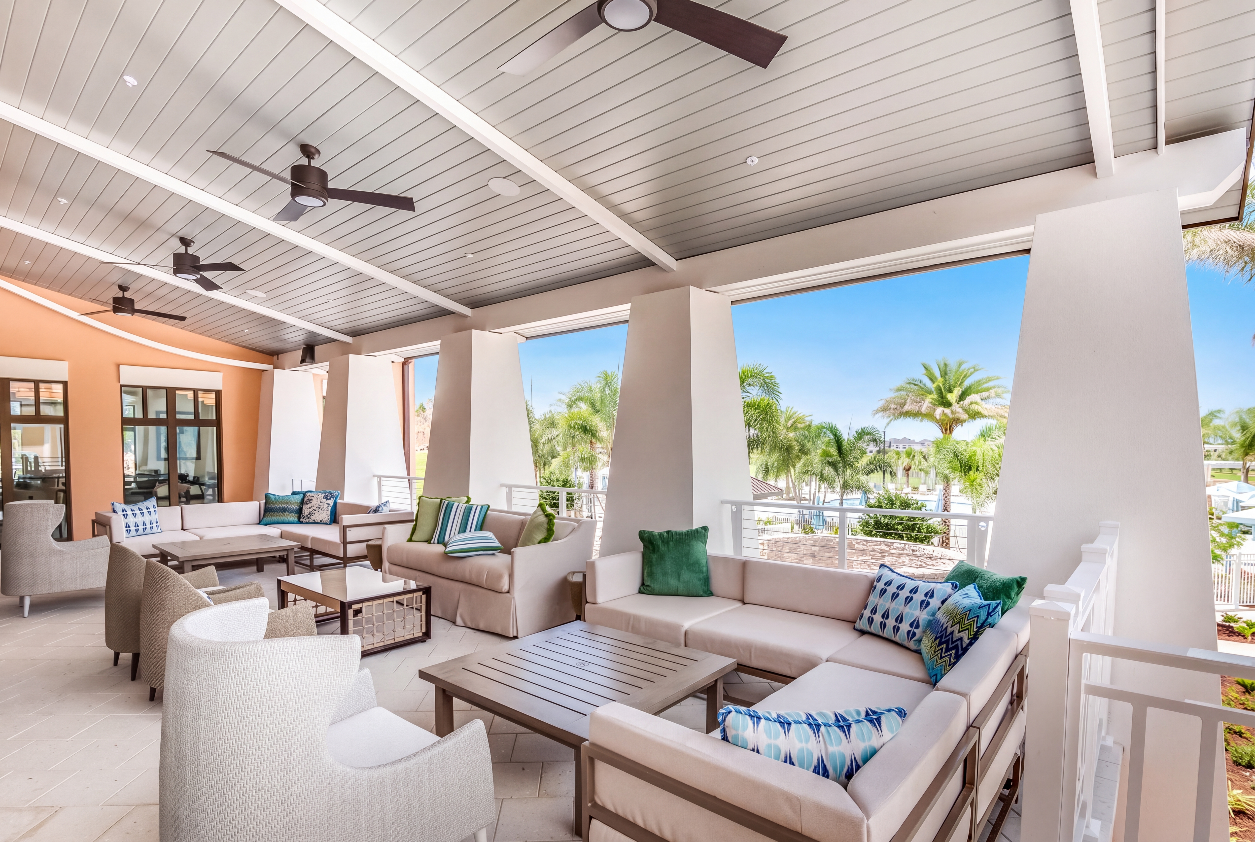 Spacious covered lanai with plush seating and tropical palm views