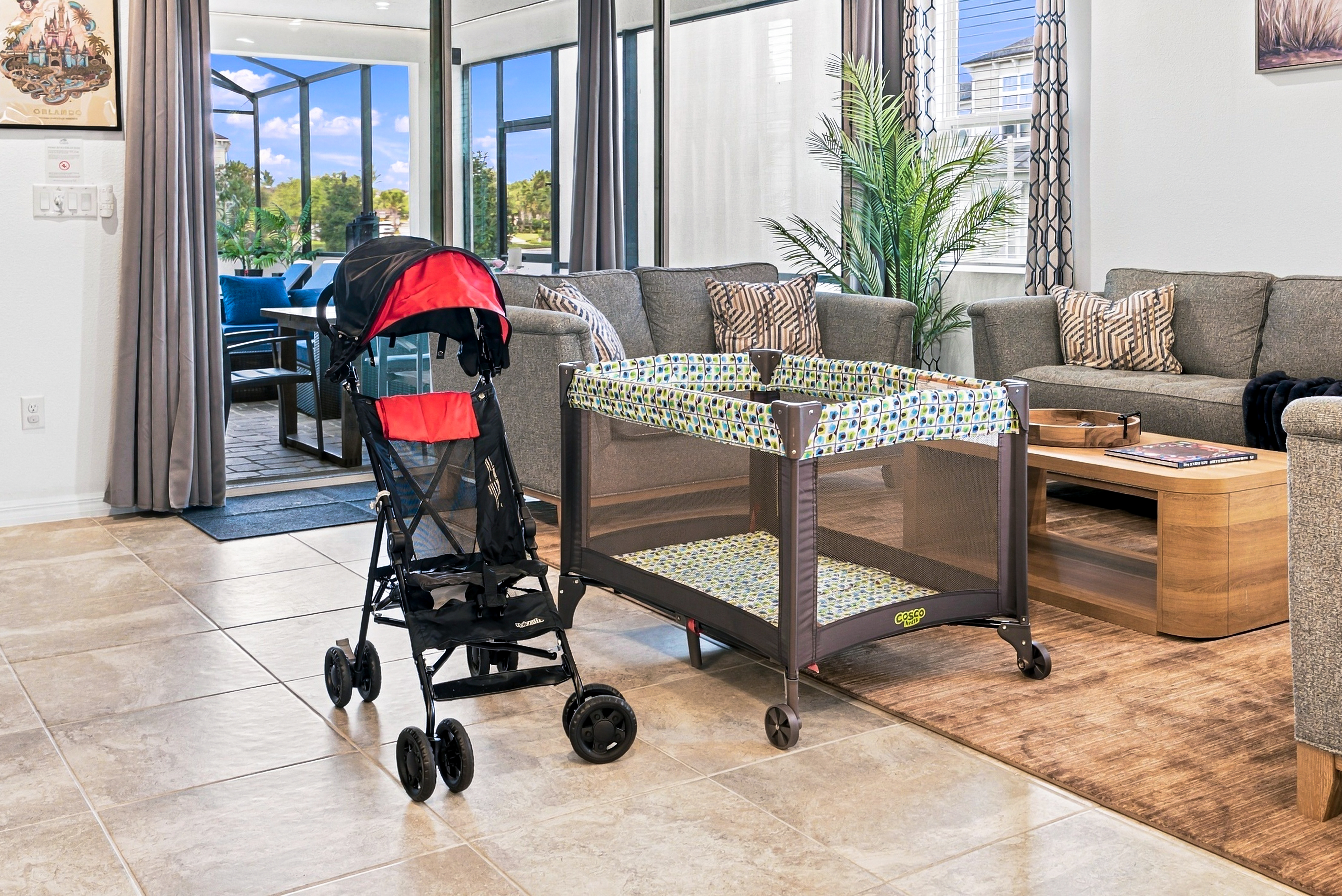 Family-friendly living room with patio access, stroller, and portable crib
