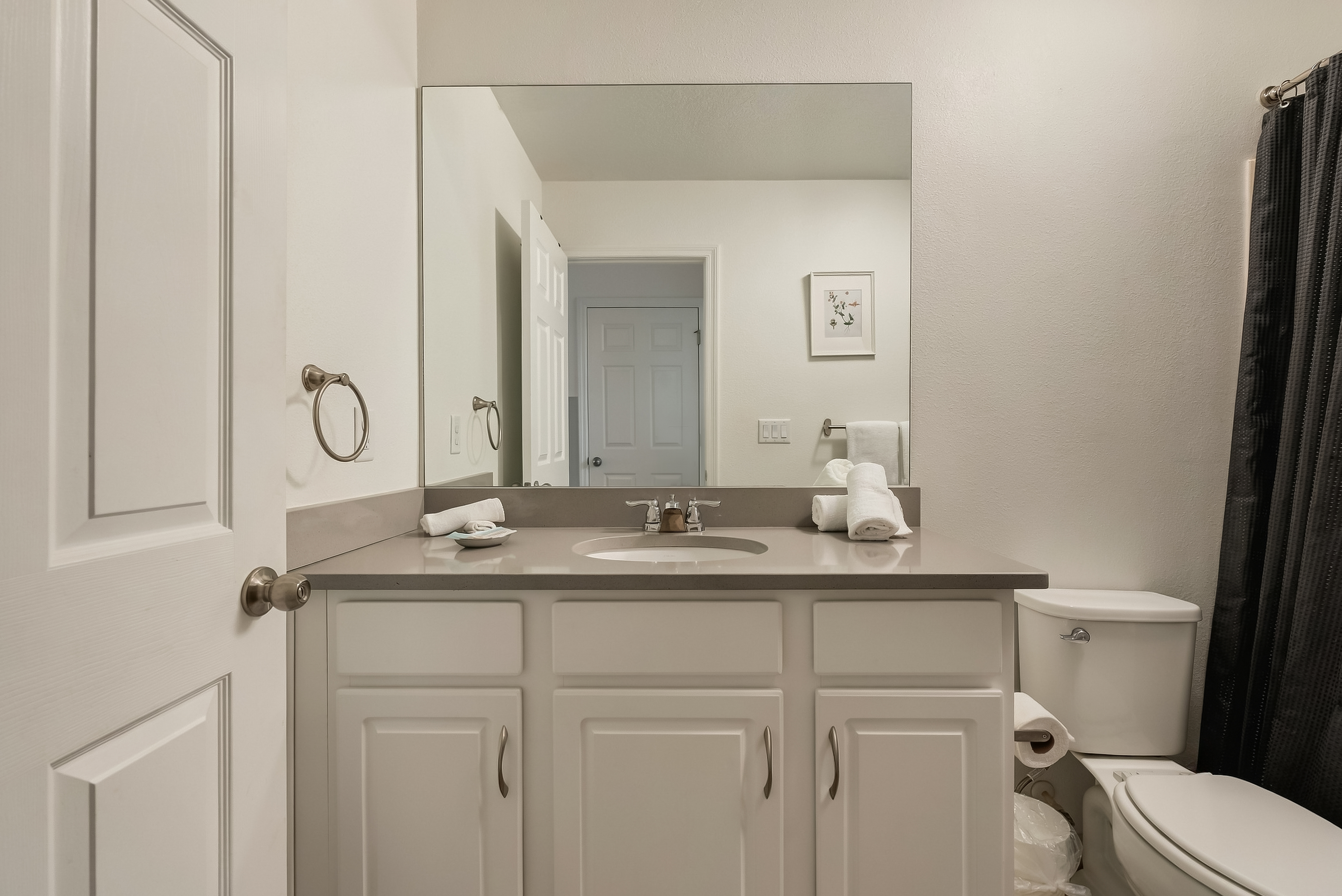 Bright, clean bathroom with large mirror and spacious vanity
