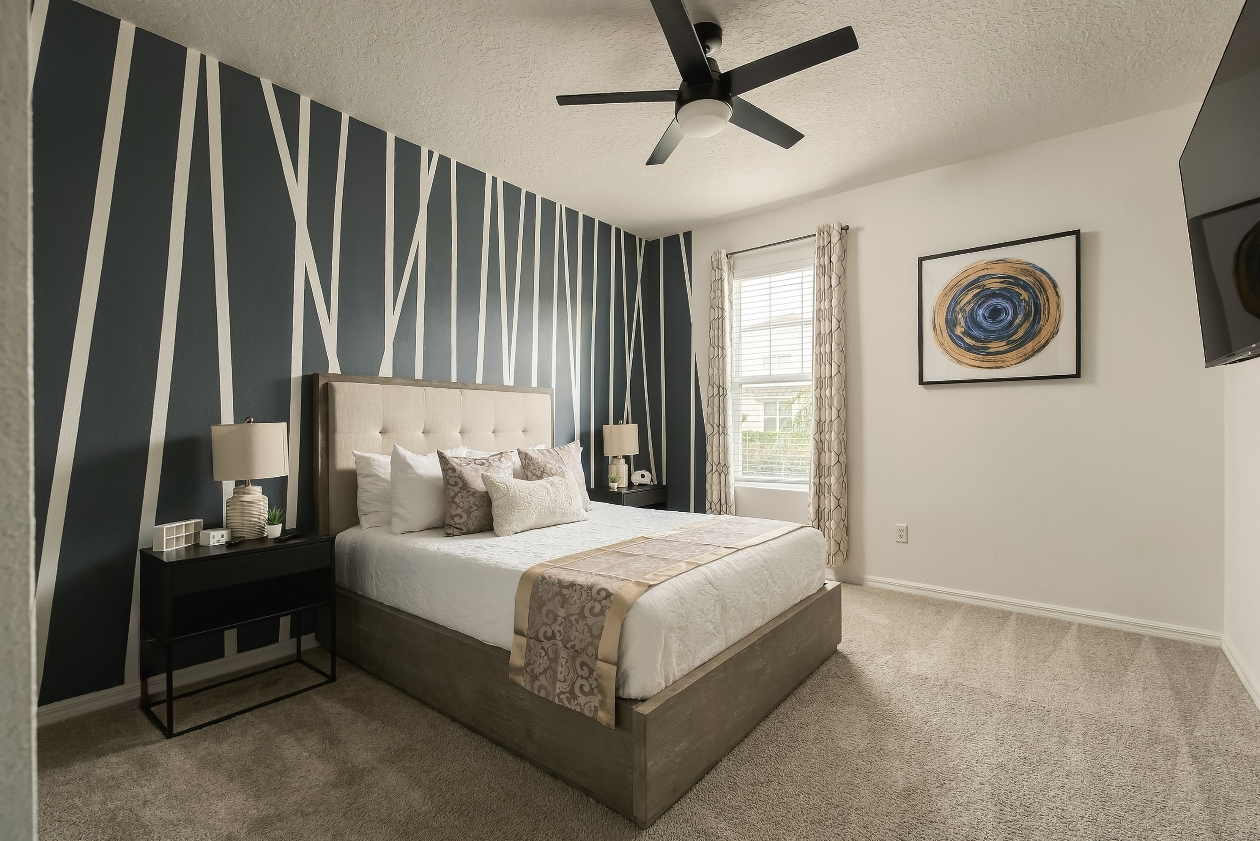 Bedroom 2 -A calm, stylish retreat on the main floor. Queen bed, smart TV, ceiling fan, and central air keep it comfortable, with a full-length mirror and a closet with hangers for settling in. A full bathroom is located just outside the door.