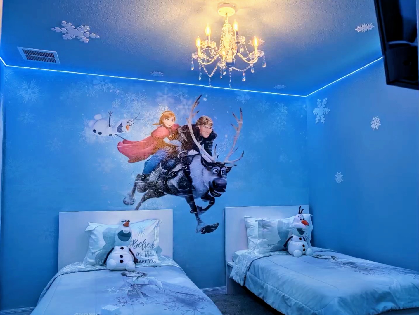 Bedroom 6- Frozen-themed twin beds with chandelier and fun blue lighting. The Ice Palace Room — a frosty blue retreat the kids won't stop talking about. Two twin beds, a smart TV, and color-changing lights keep them happy from playtime to bedtime.
