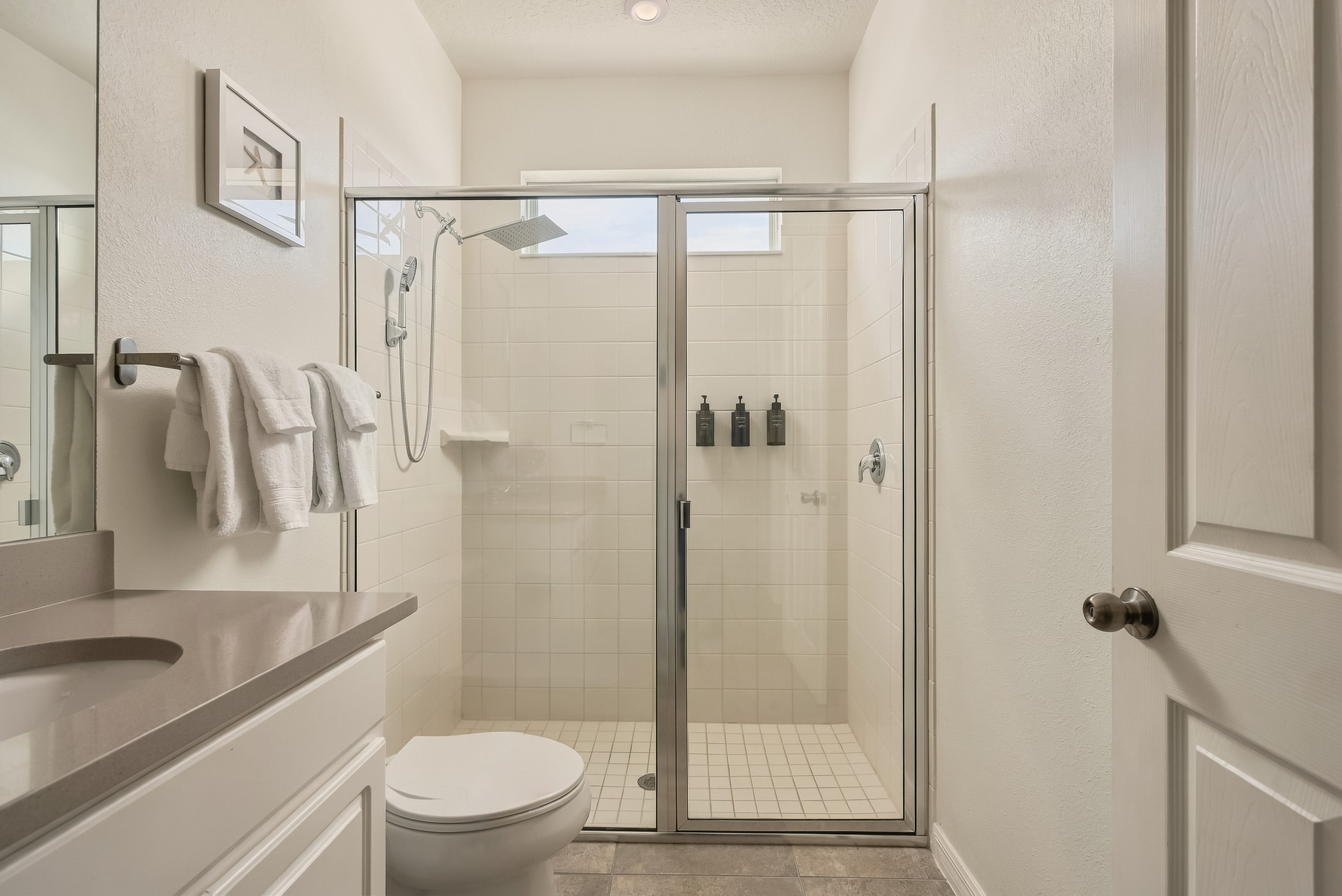 Bright bathroom with spacious glass walk-in shower and clean modern finishes