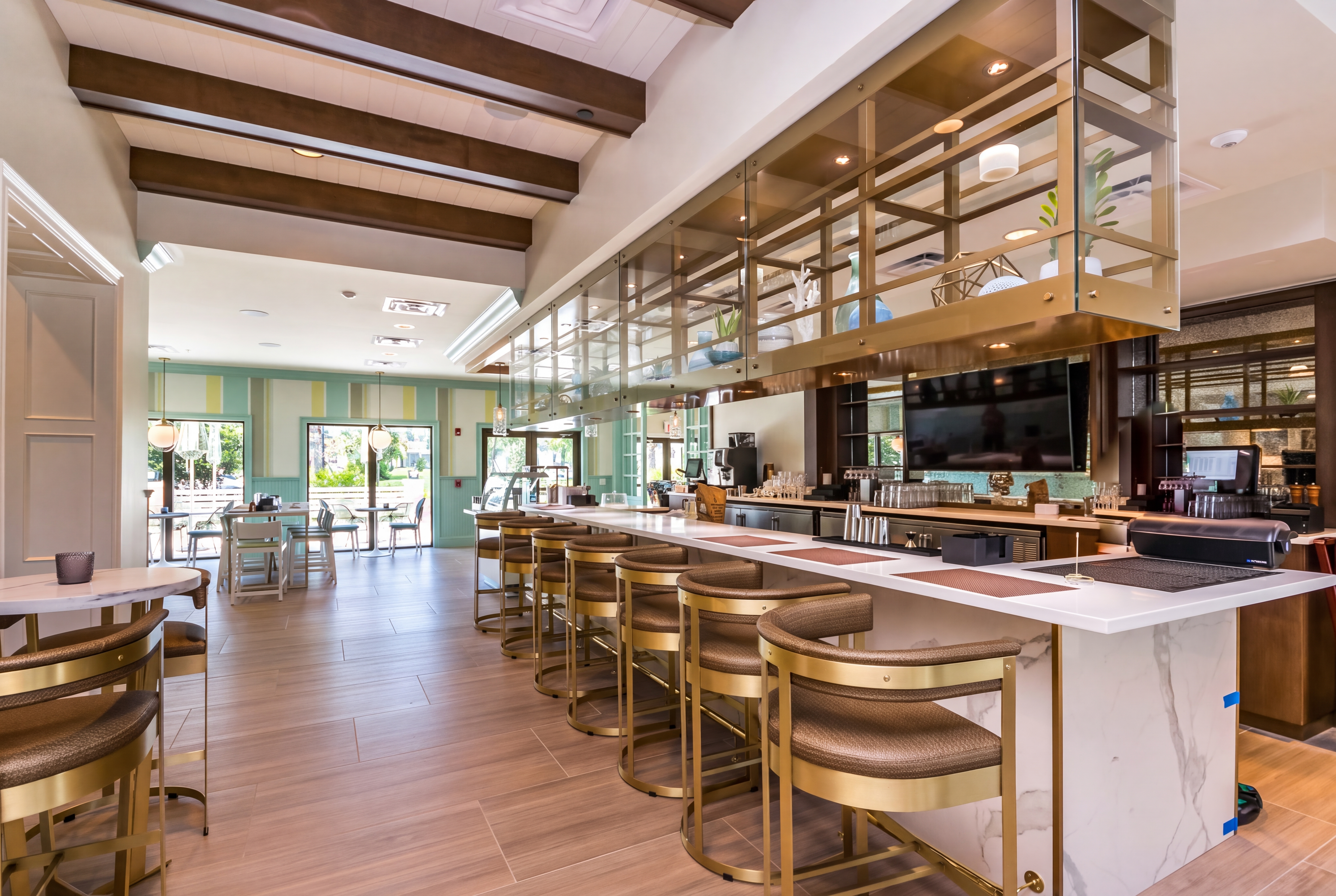 Chic lounge bar with marble counters, gold accents, and bright social seating
