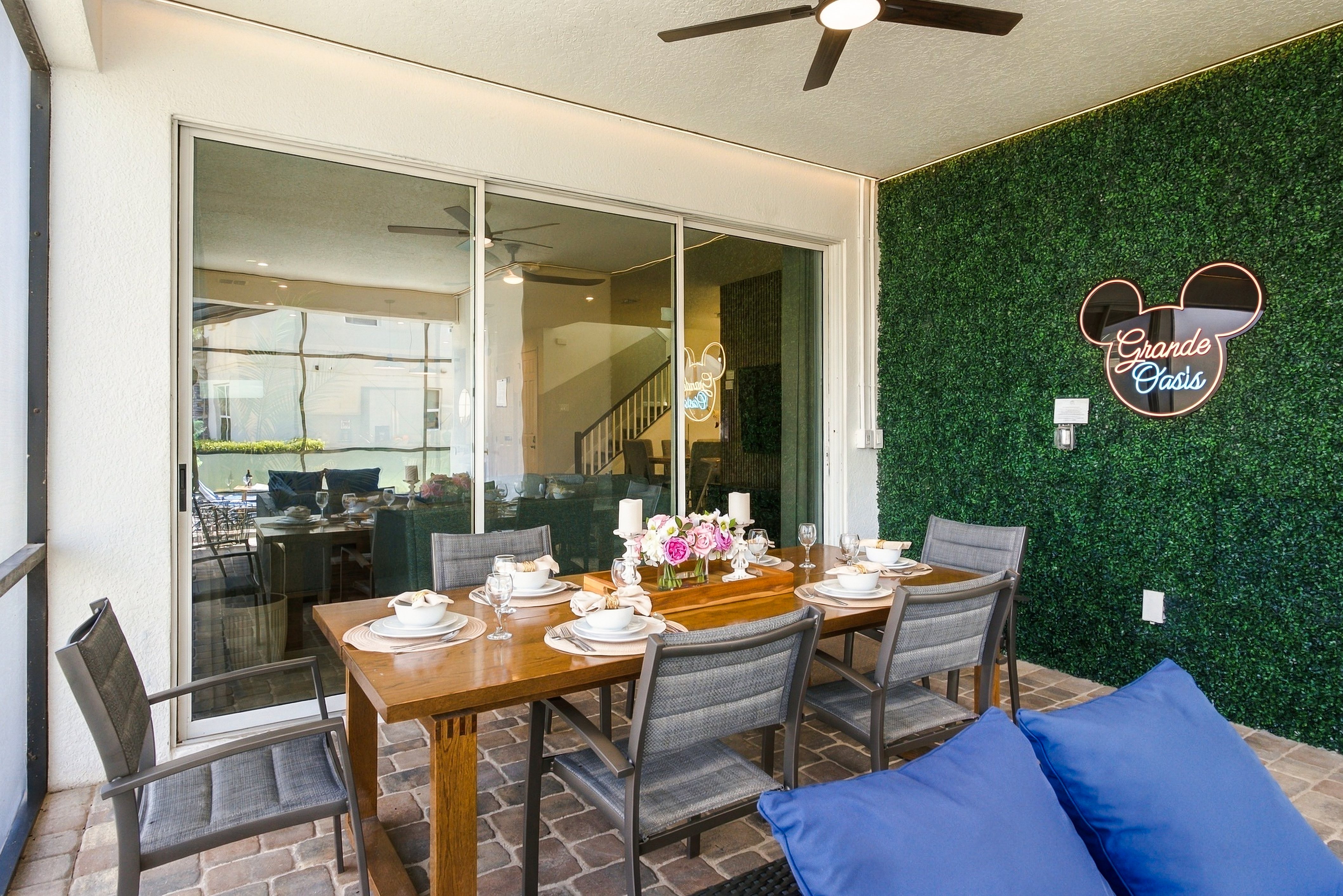 Covered patio dining for 6 with stylish greenery wall and cozy ambiance