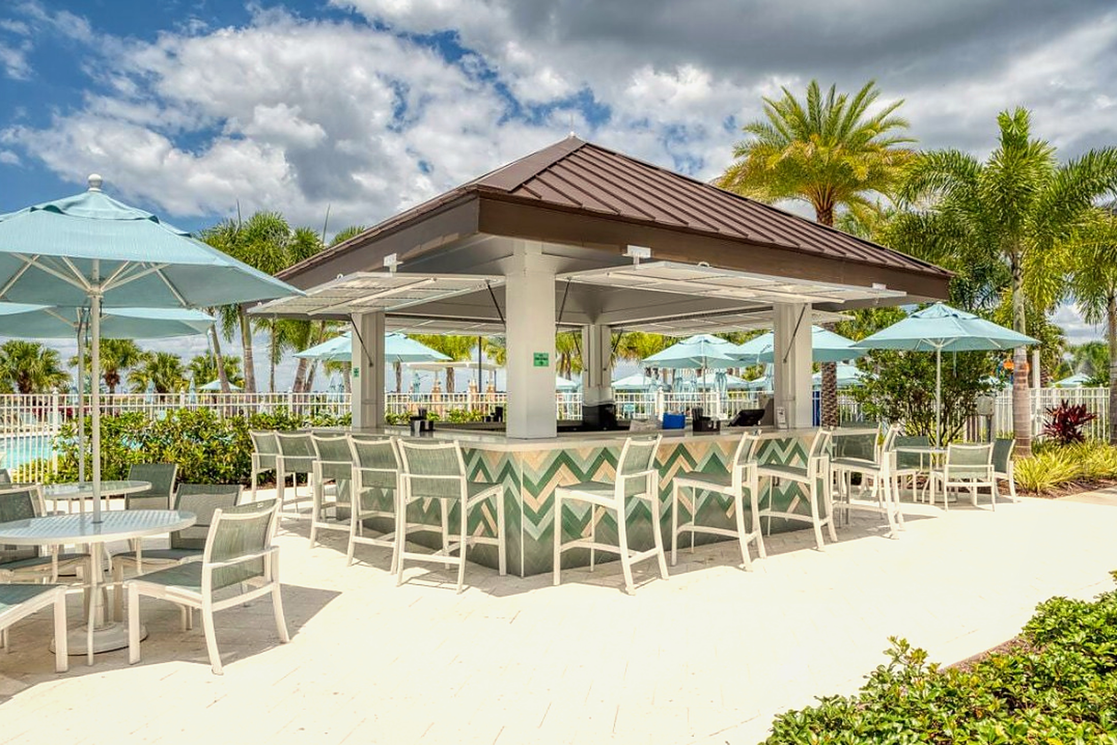 Resort-style poolside bar with shaded seating and tropical vibes
