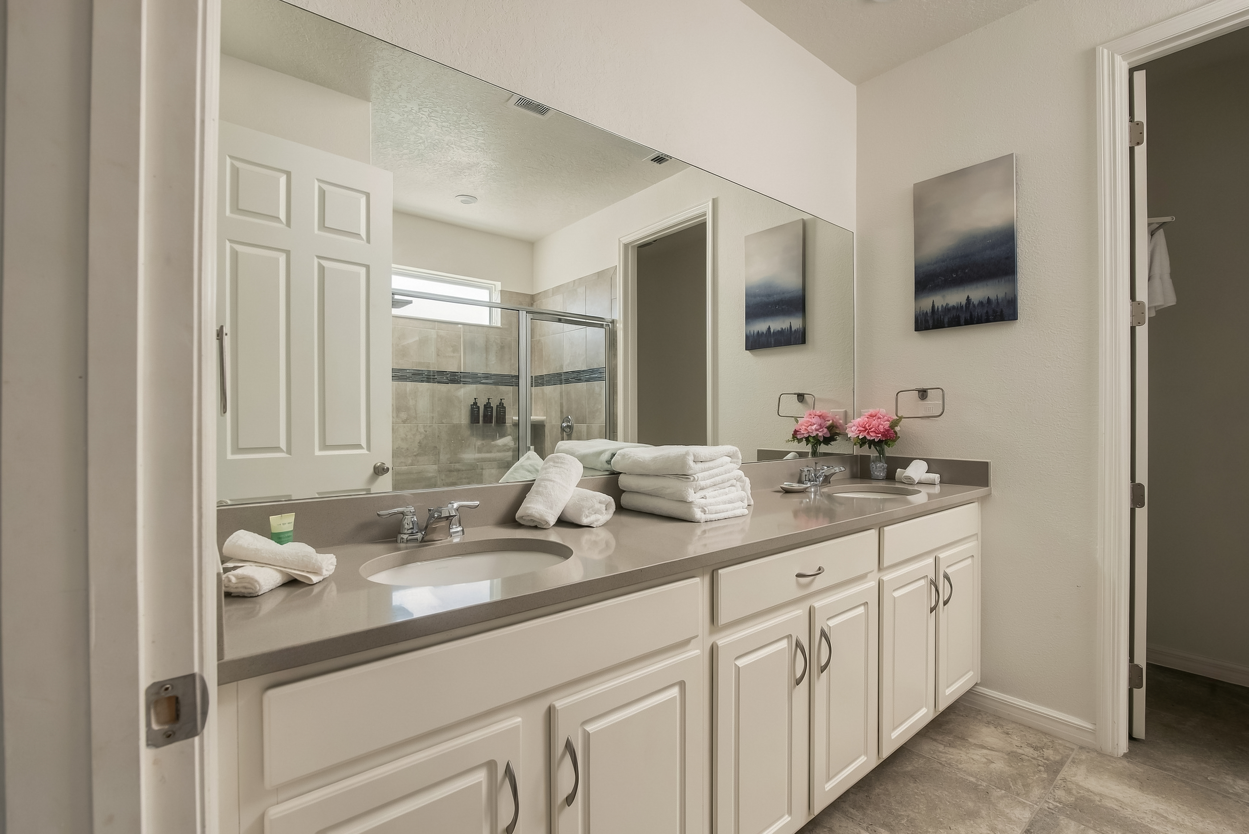 Bright double-vanity bathroom with spacious walk-in glass shower