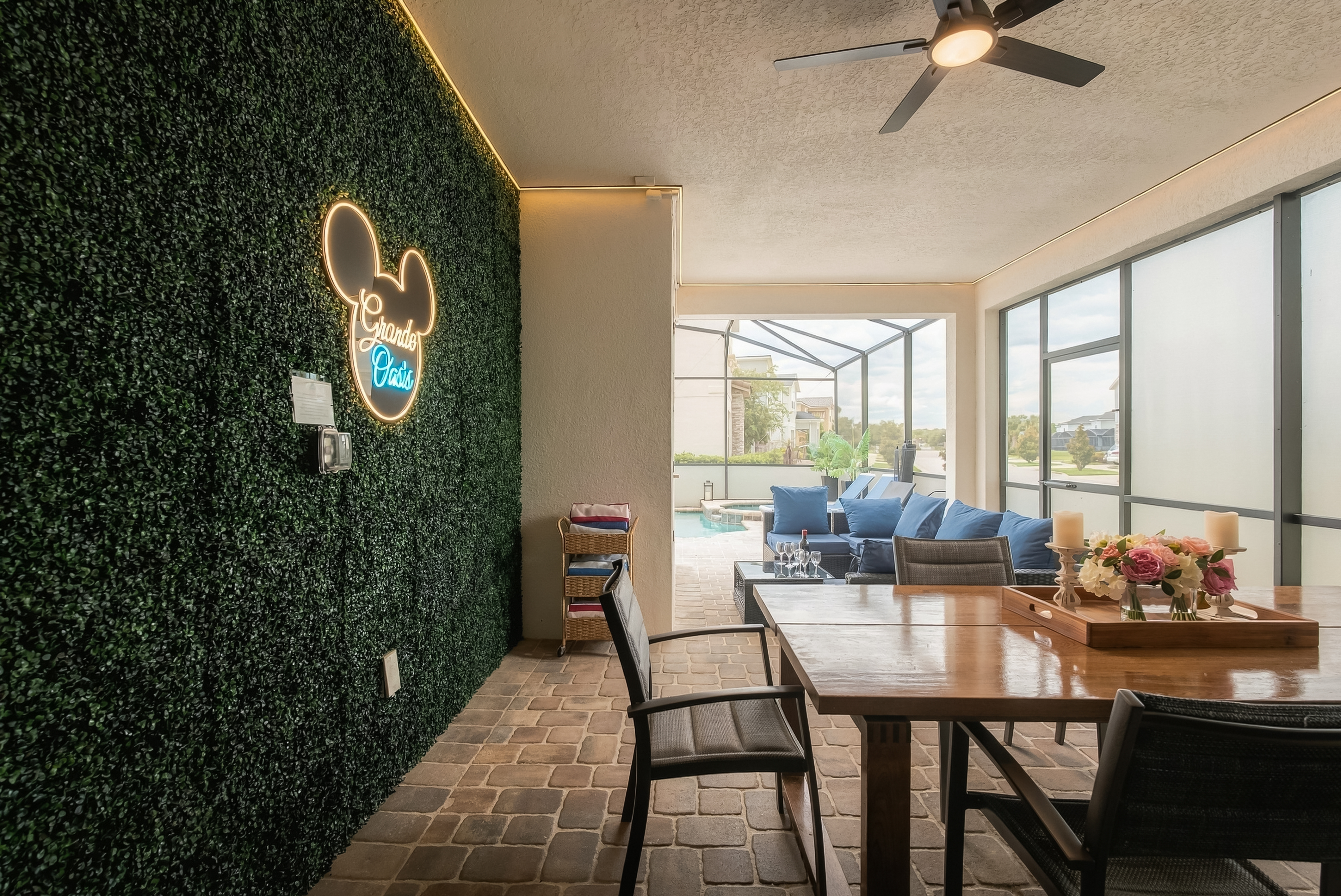 Stylish screened lanai with pool views, dining space, and cozy lounge seating