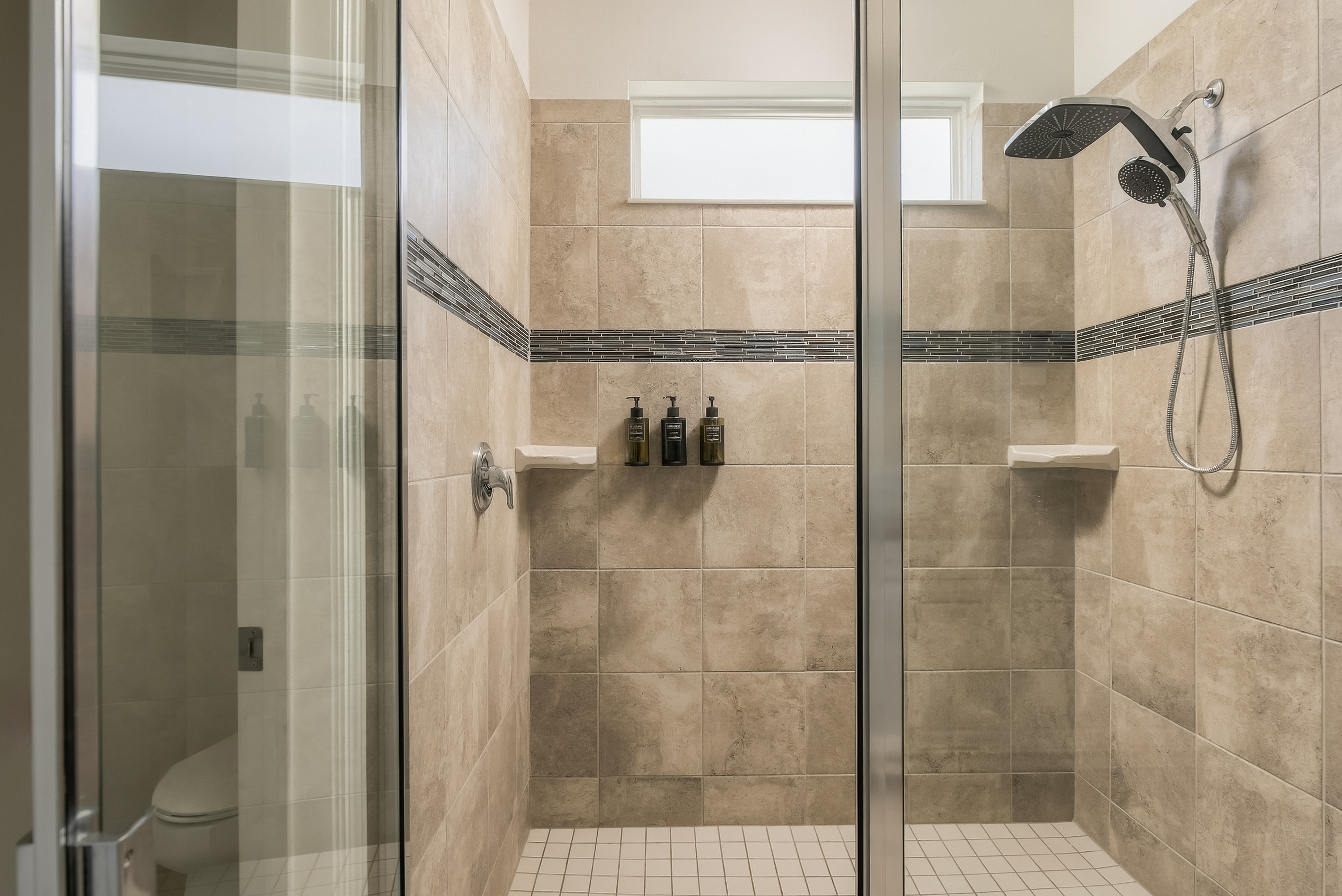 Spa-style walk-in shower with rainfall head and elegant tile details