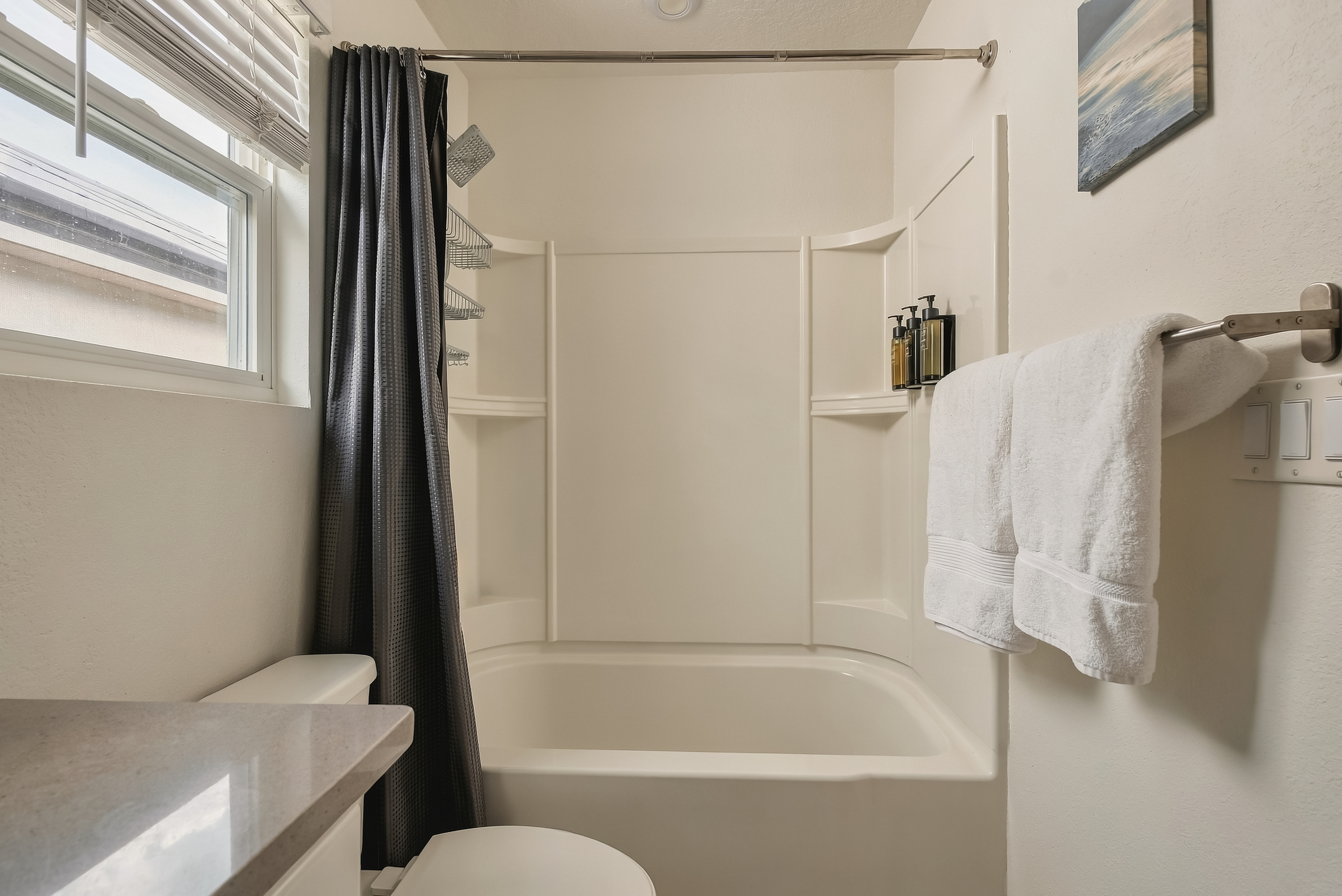 Bright bathroom with tub-shower combo and fresh, modern touches