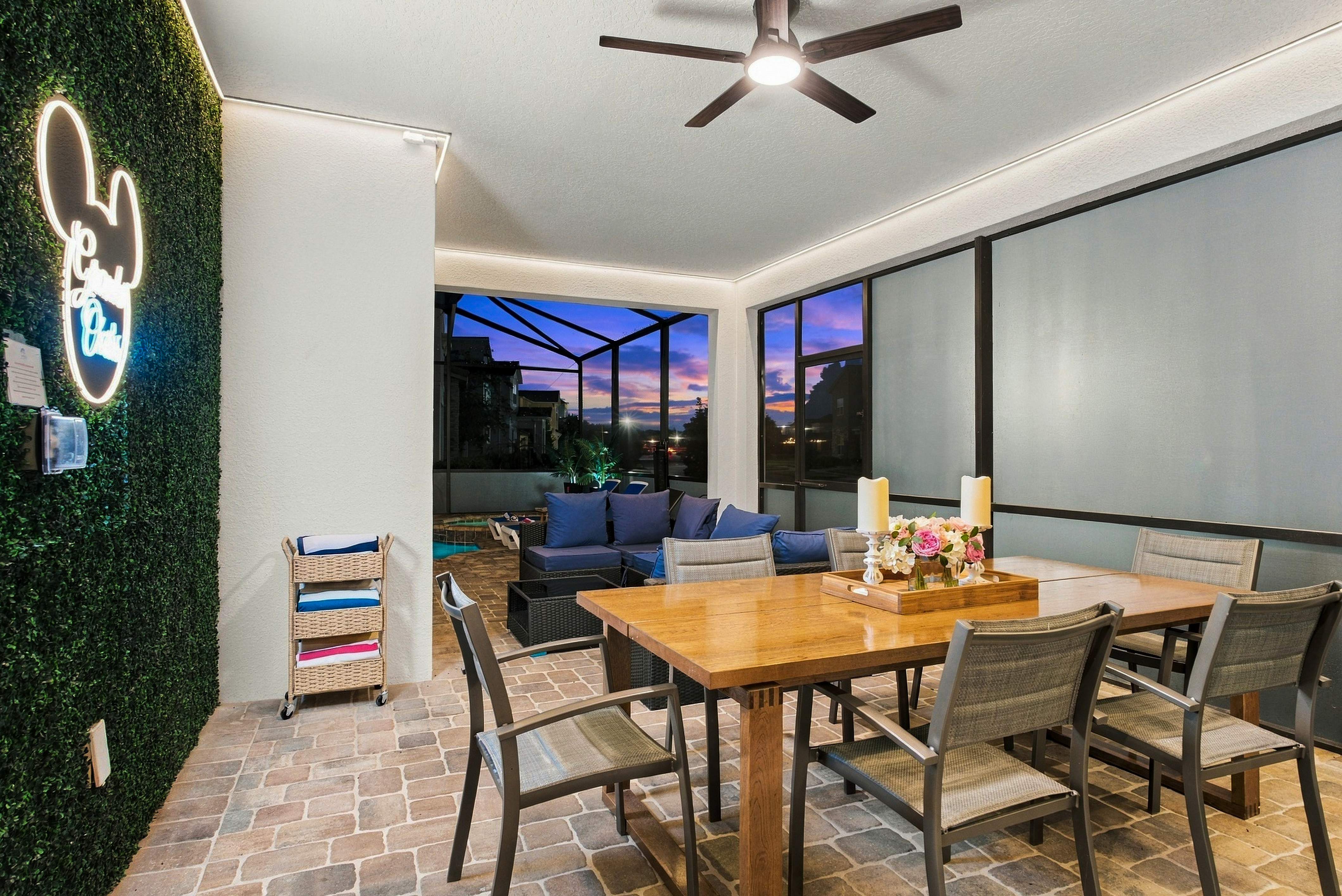 Stylish screened patio with sunset views, dining table, and cozy lounge seating