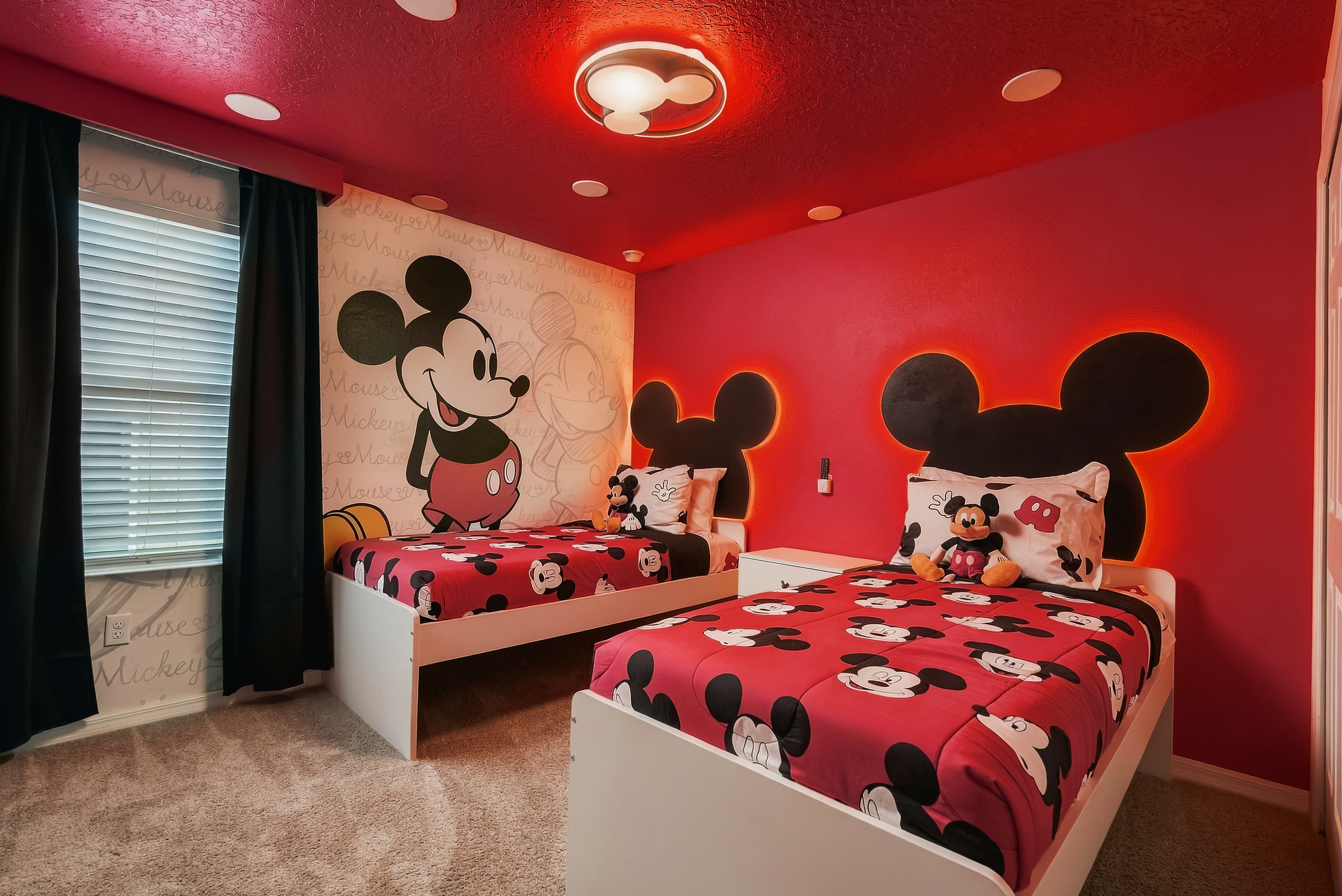 Fun Mickey-themed twin bedroom with glowing headboards and playful Disney style