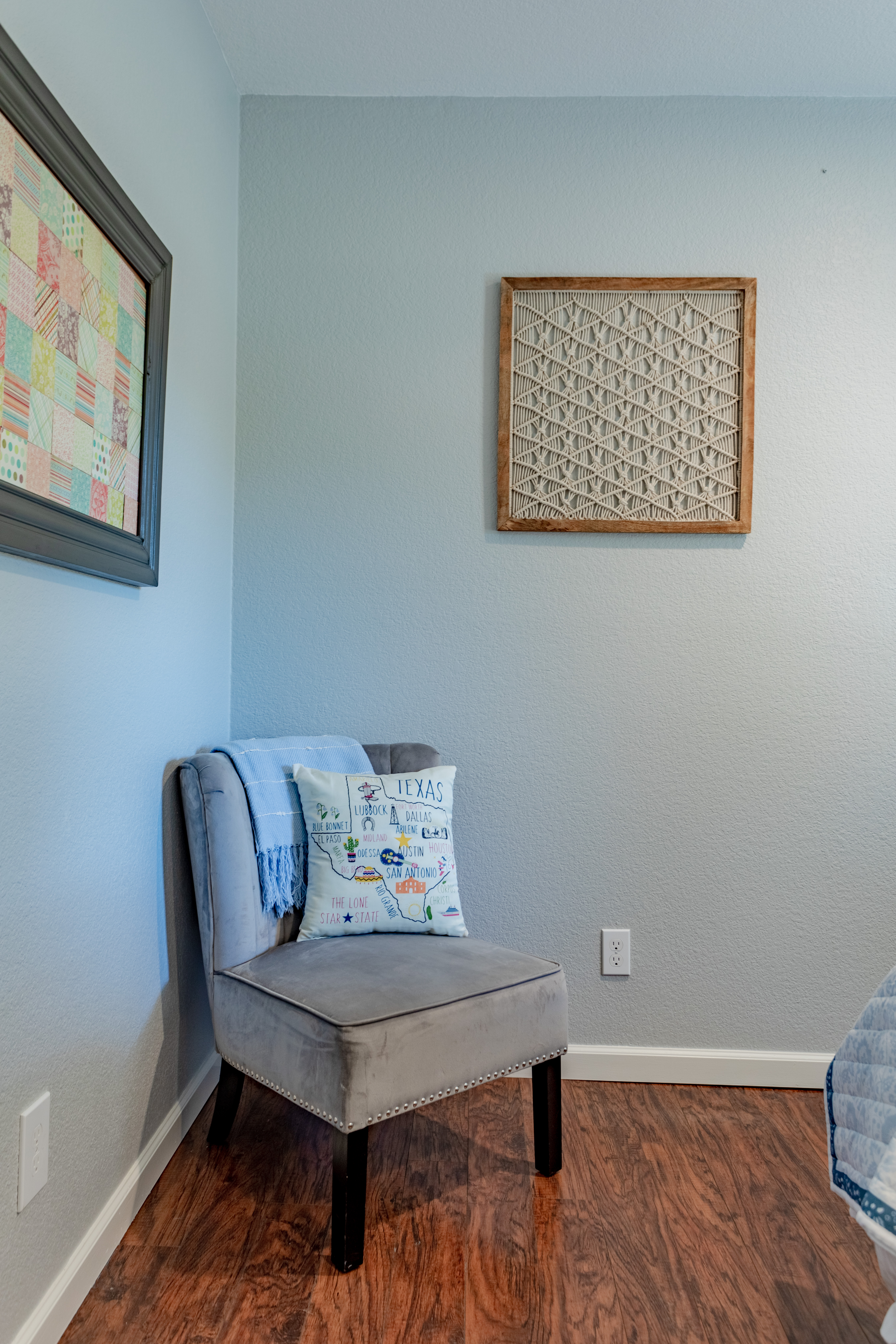 Cozy bedroom nook with accent chair, throw blanket, and stylish wall art