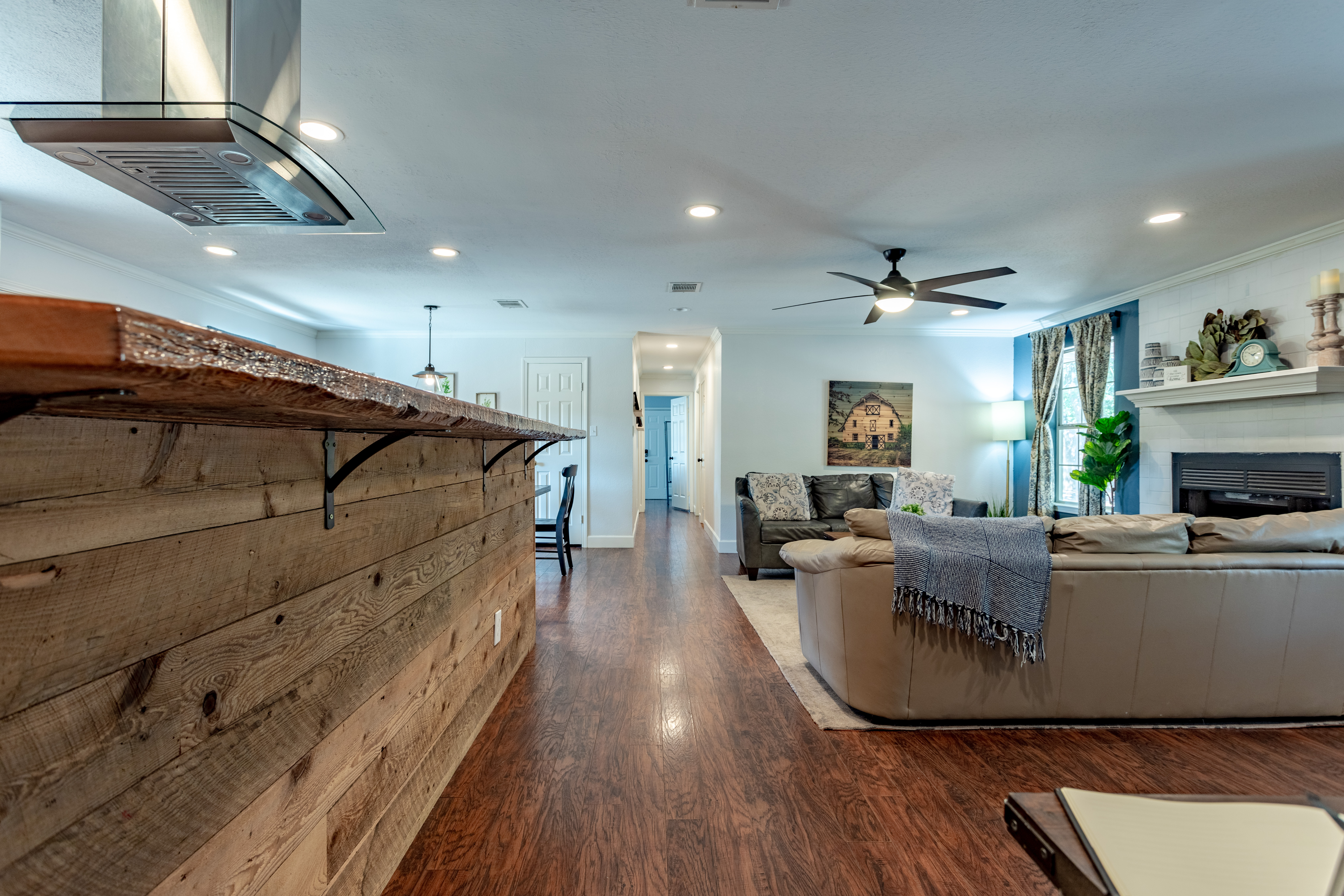 Bright open living space with rustic charm, cozy seating, and fireplace