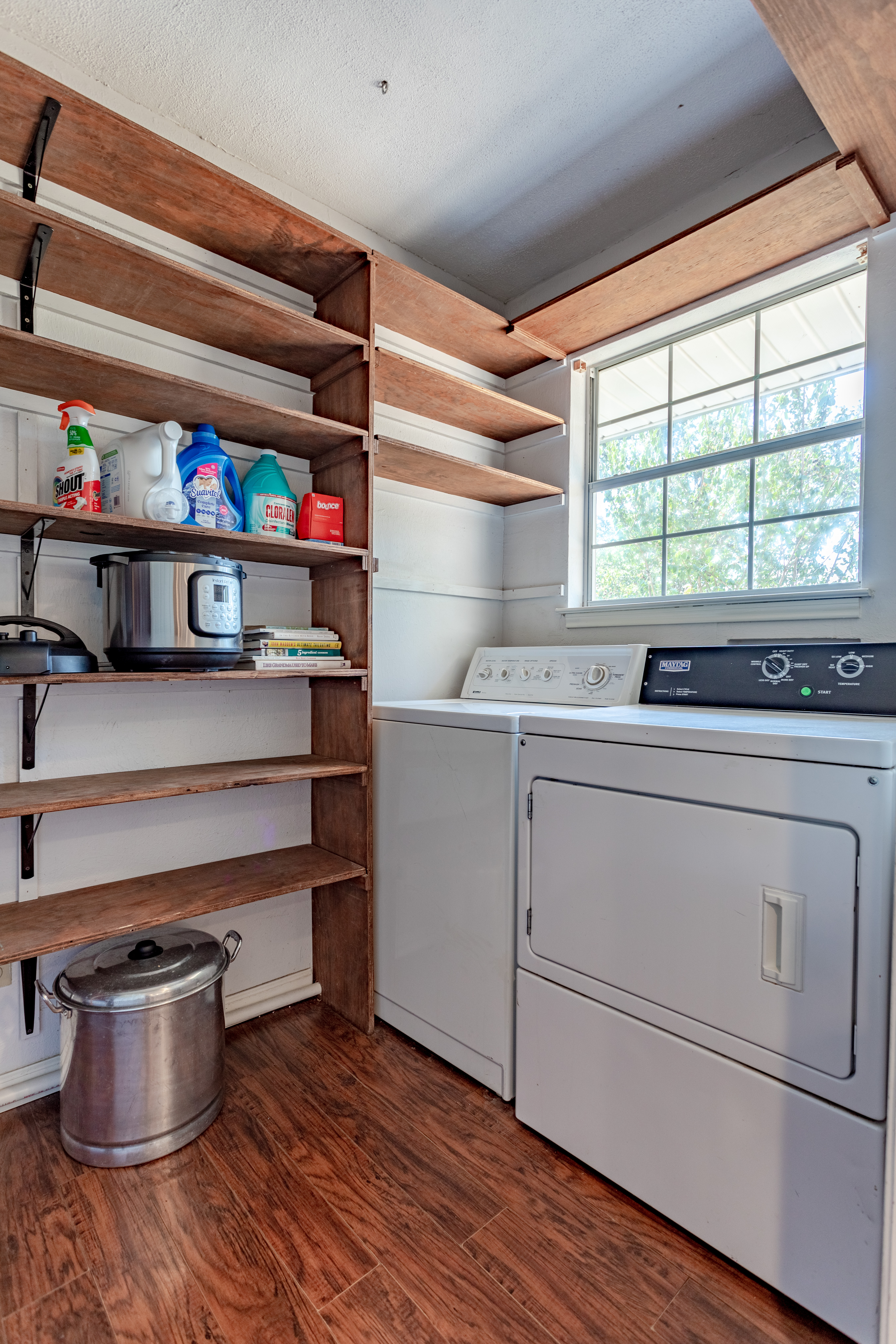Bright laundry room with washer/dryer and plenty of open shelf storage
