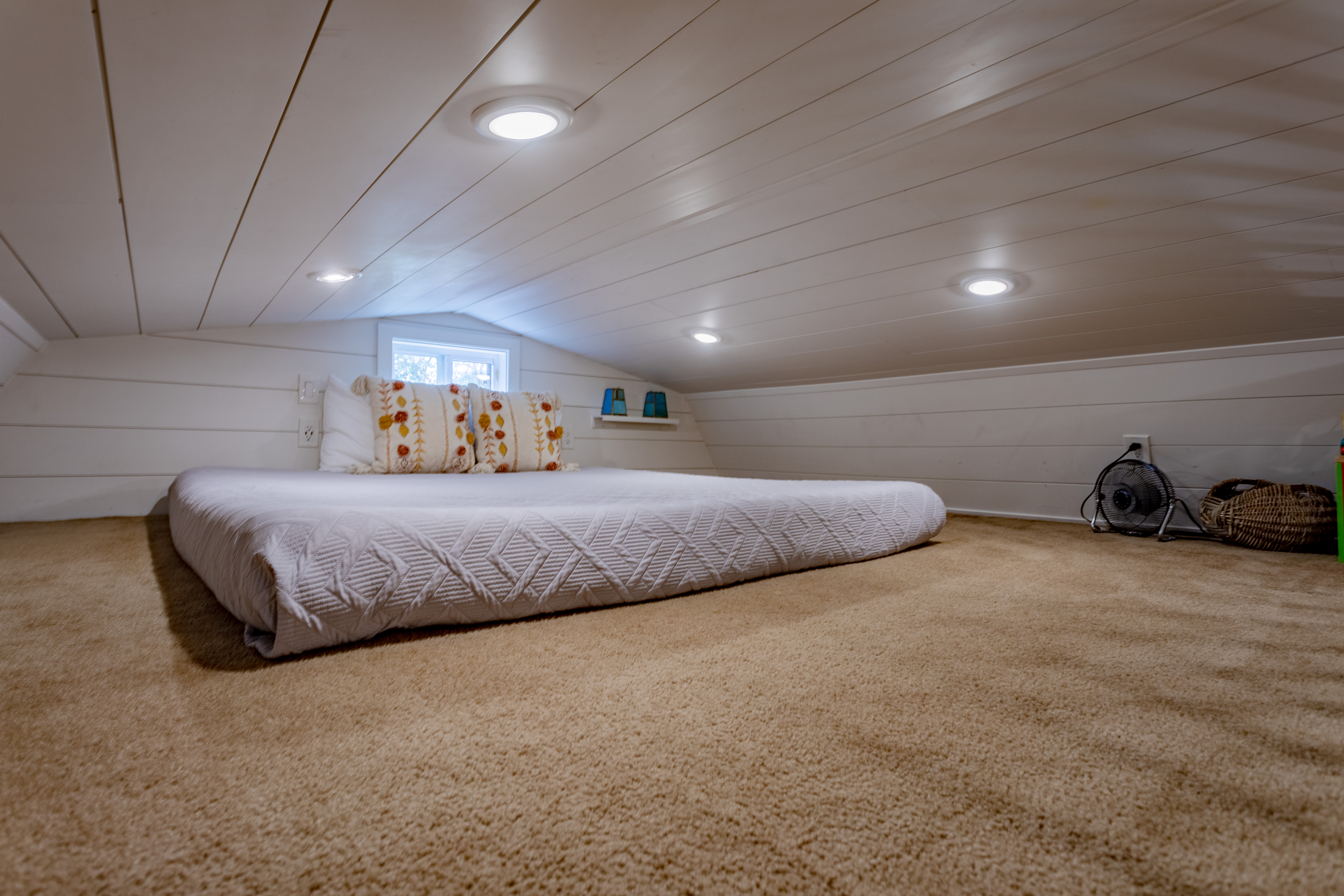 Cozy loft sleeping nook with soft carpet and bright, inviting charm