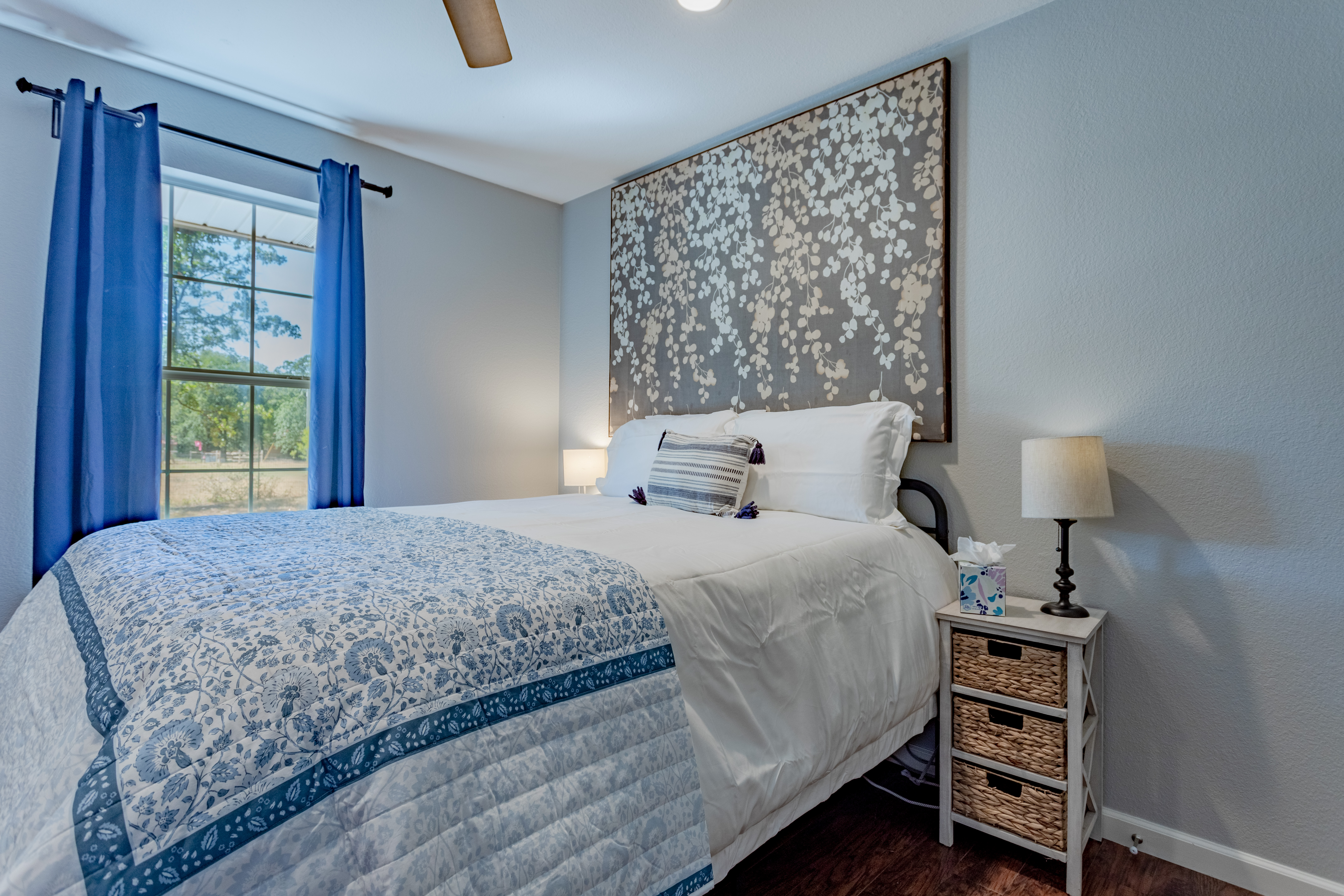 Bright, cozy bedroom with large window, stylish decor, and soft linens