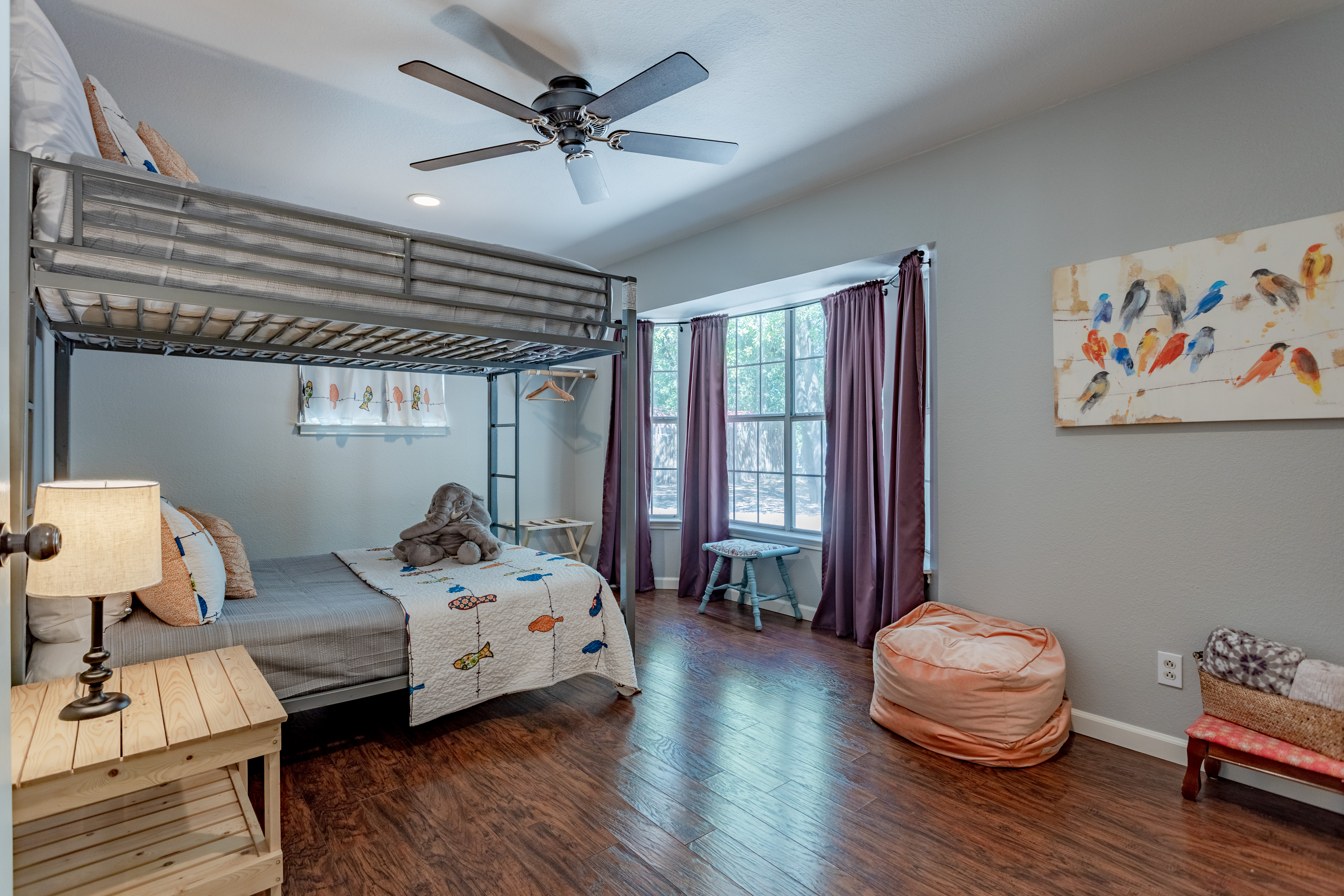 Bright family-friendly bunk room with hardwood floors and sunny window nook