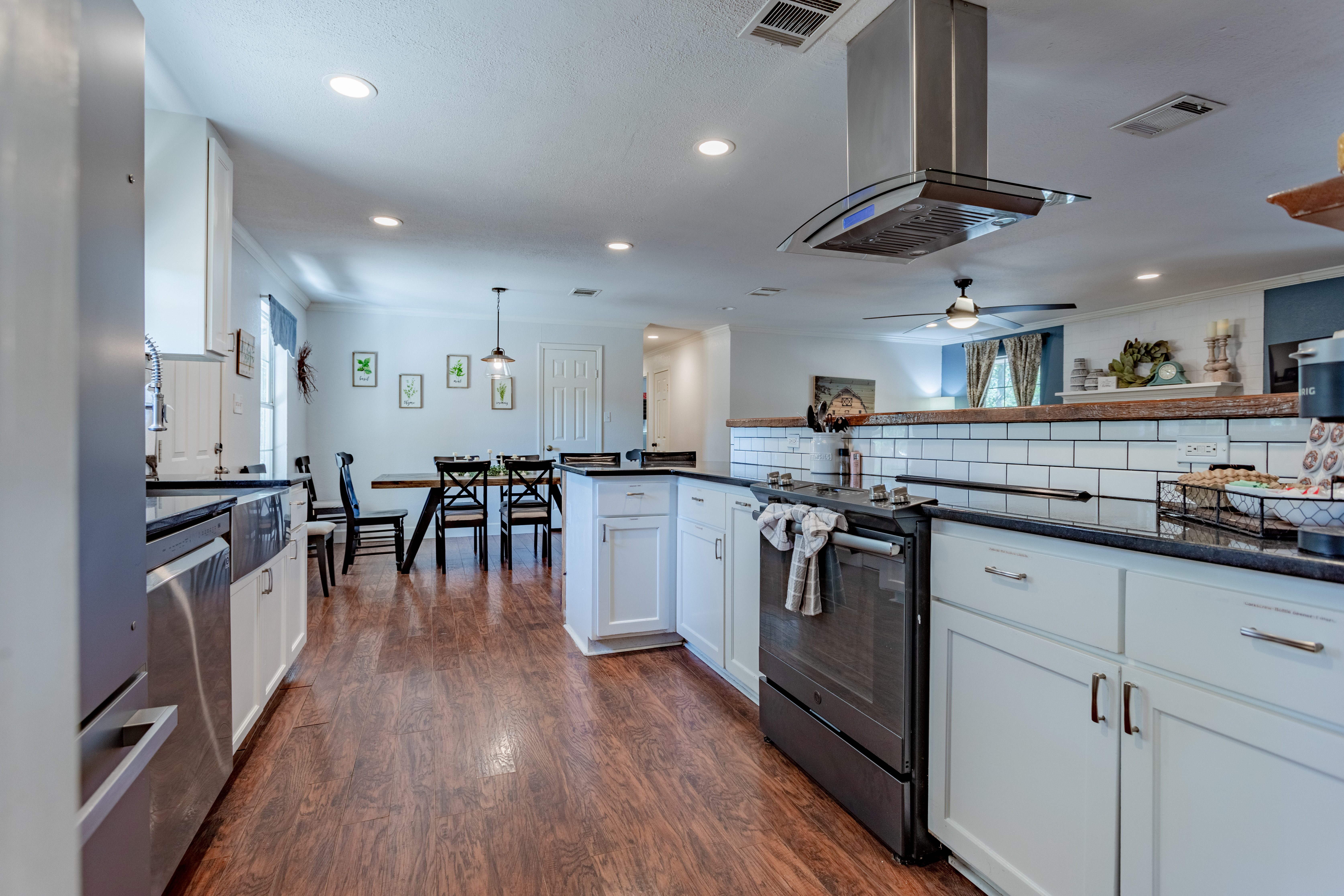 Bright open kitchen with island, dining space, and modern stainless finishes