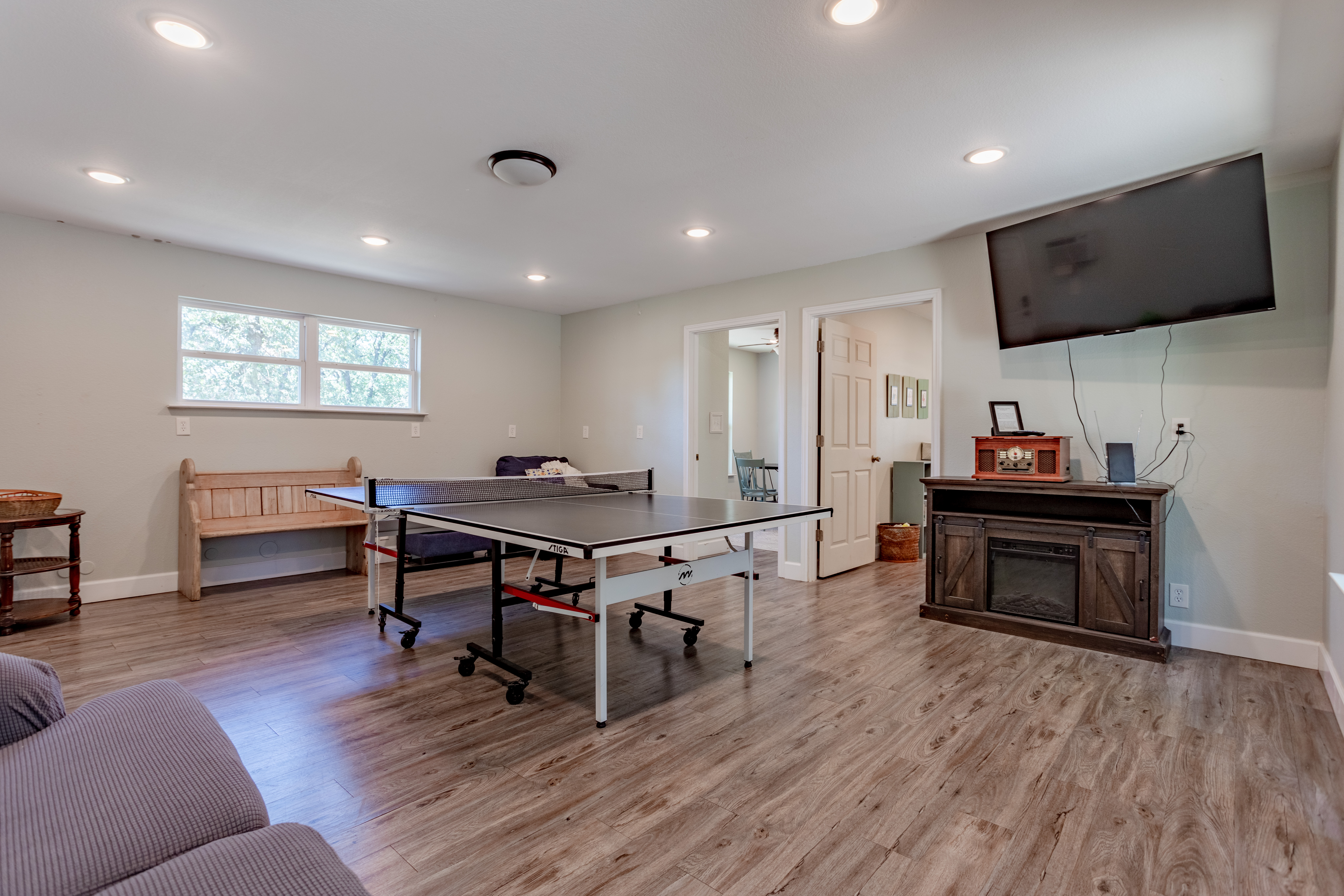 Spacious game room with ping pong table and wall-mounted TV