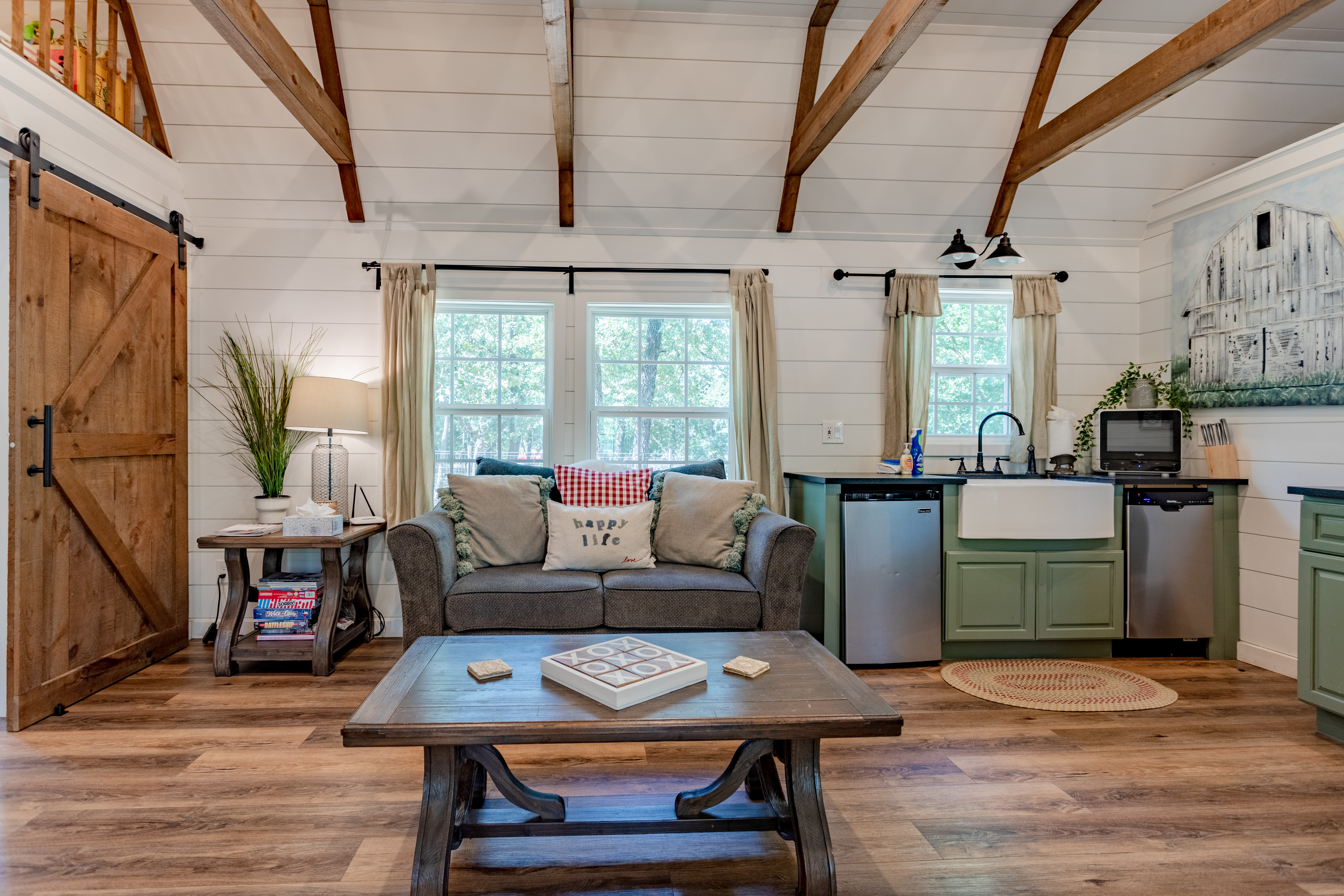 Cozy cabin-style living space with kitchenette and soaring beam ceilings