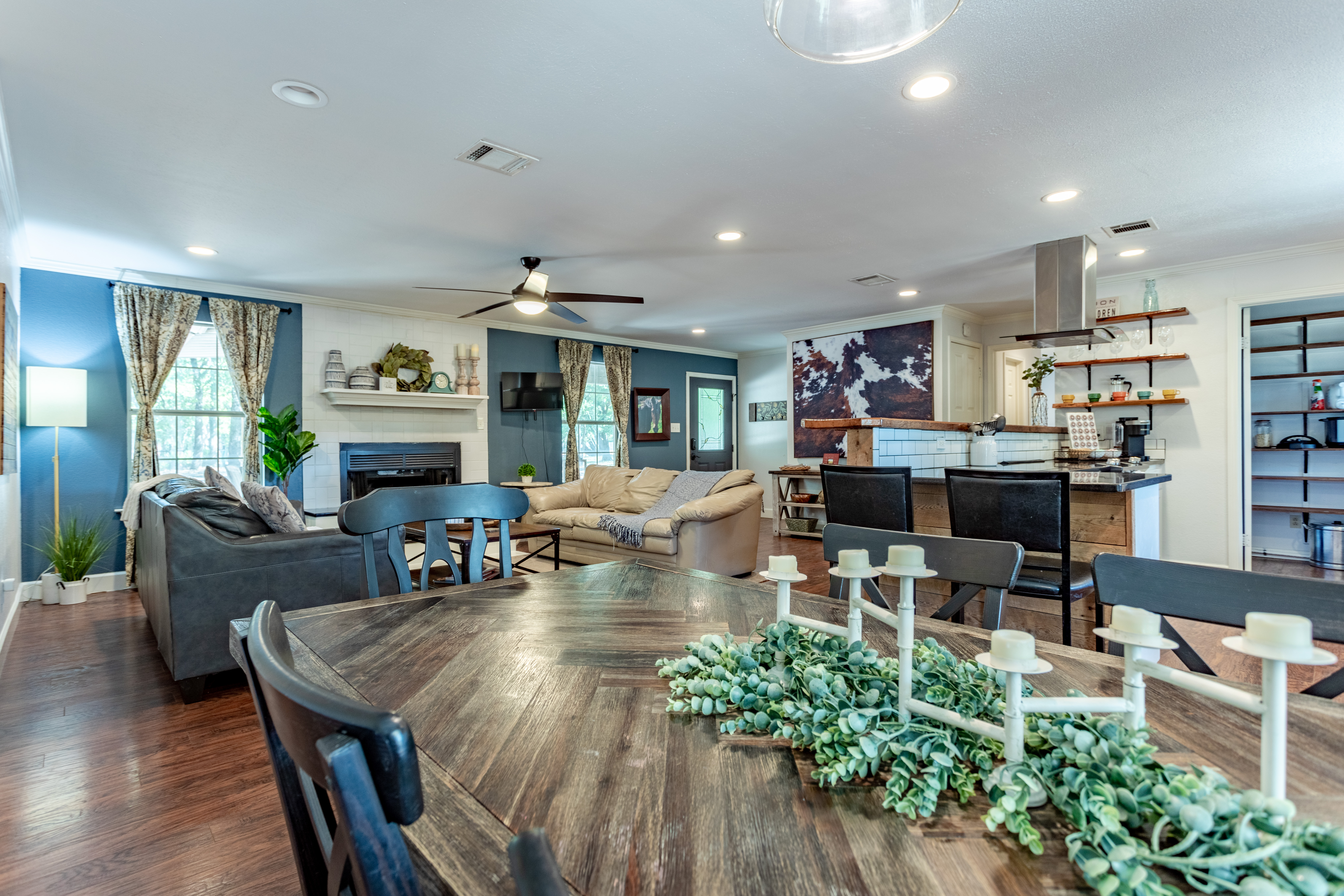 Spacious open-concept living with fireplace, dining table, and modern kitchen