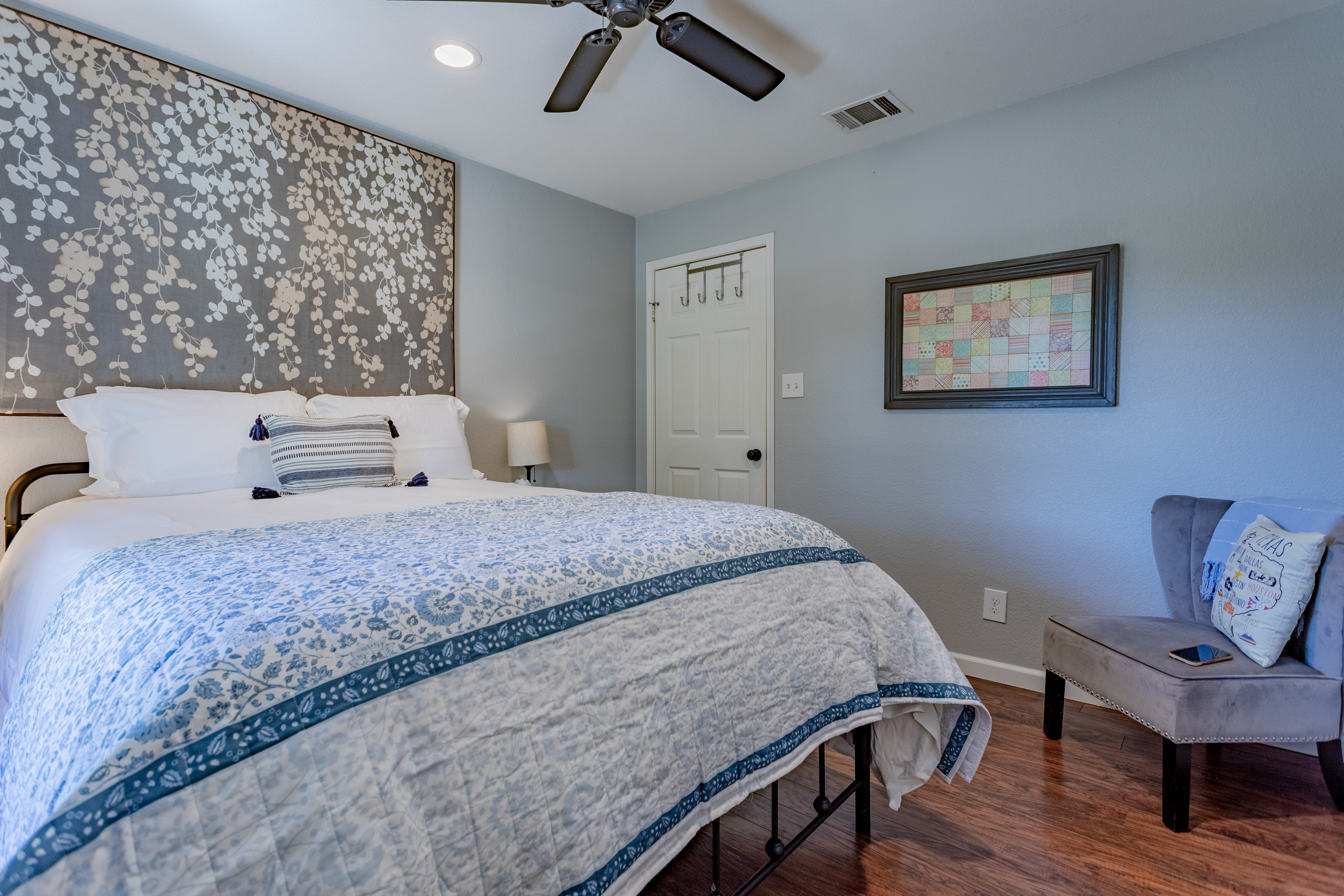 Cozy, stylish bedroom with plush bedding, accent chair, and serene decor