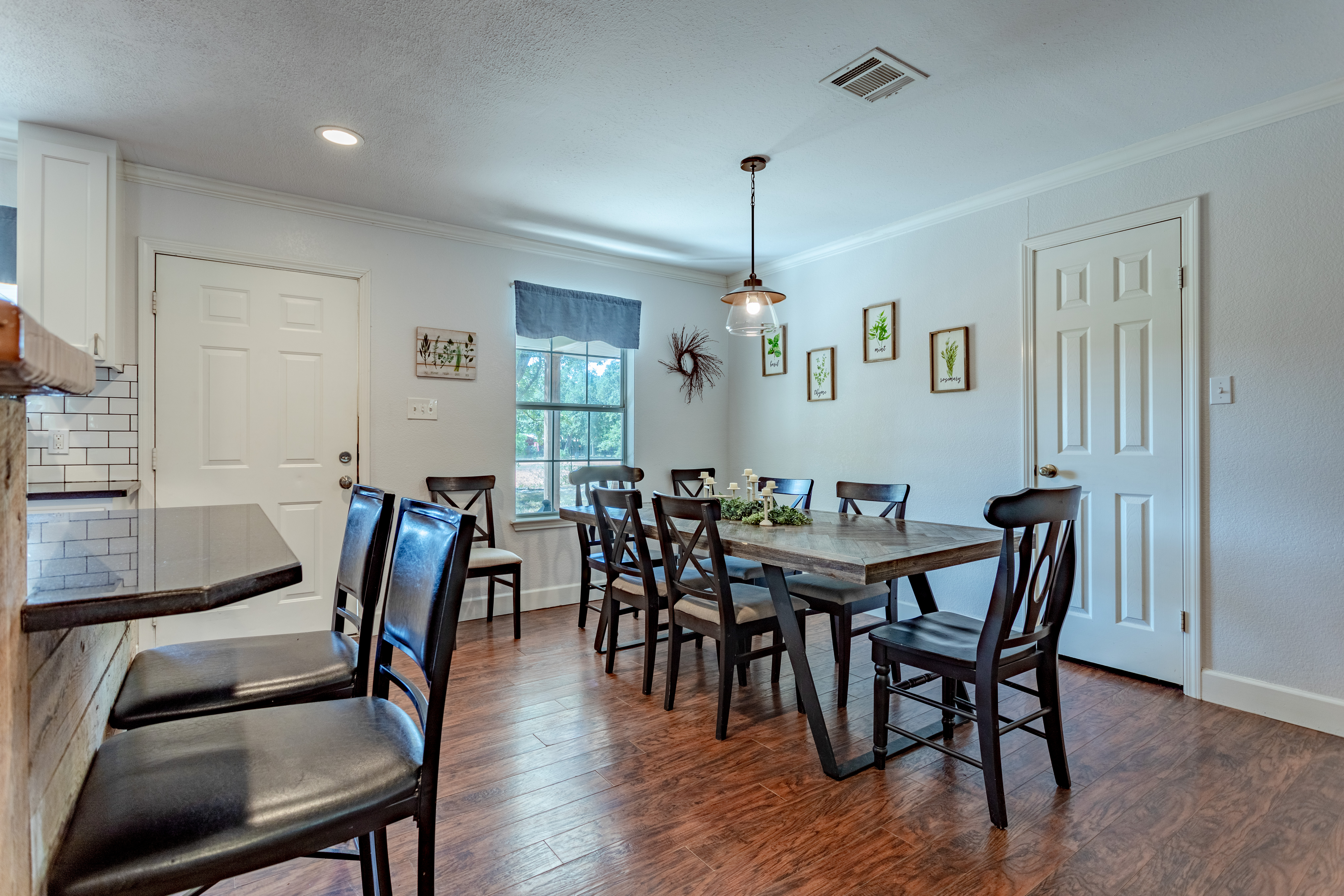 Bright dining space with rustic table, seating for six, plus bar stools