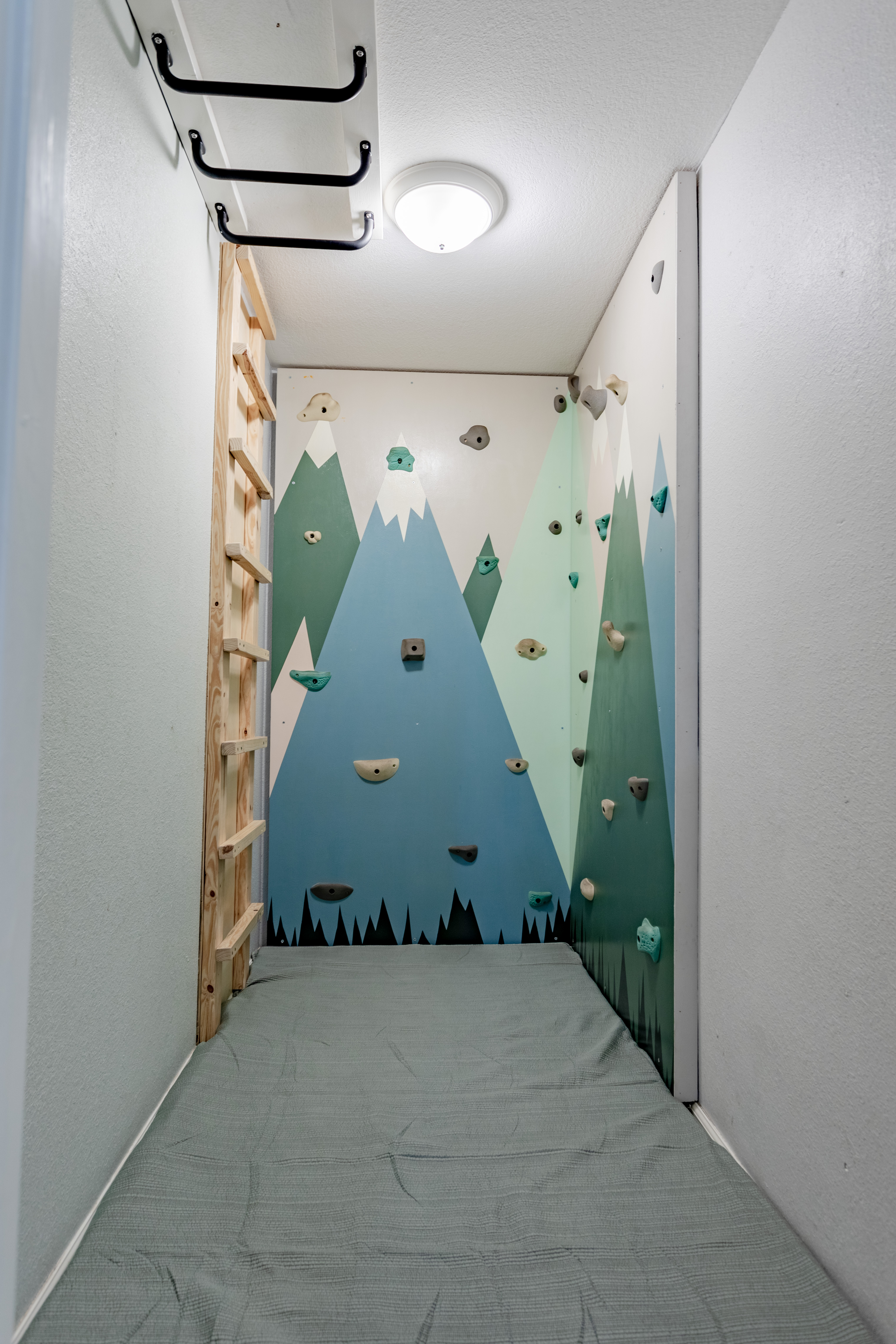 Fun indoor kids’ climbing nook with mountain mural and padded play zone