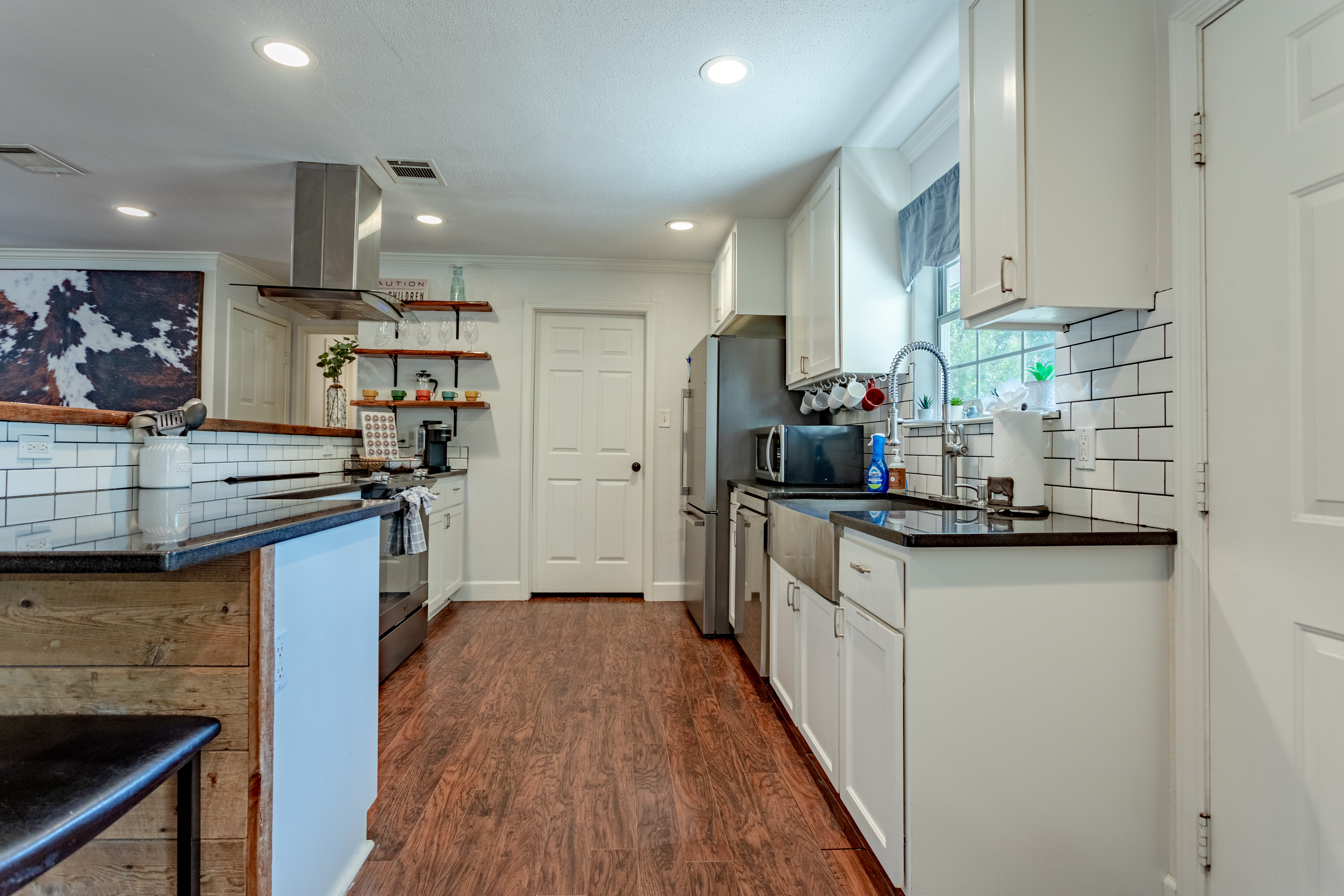 Bright modern kitchen with stainless appliances and stylish open shelving