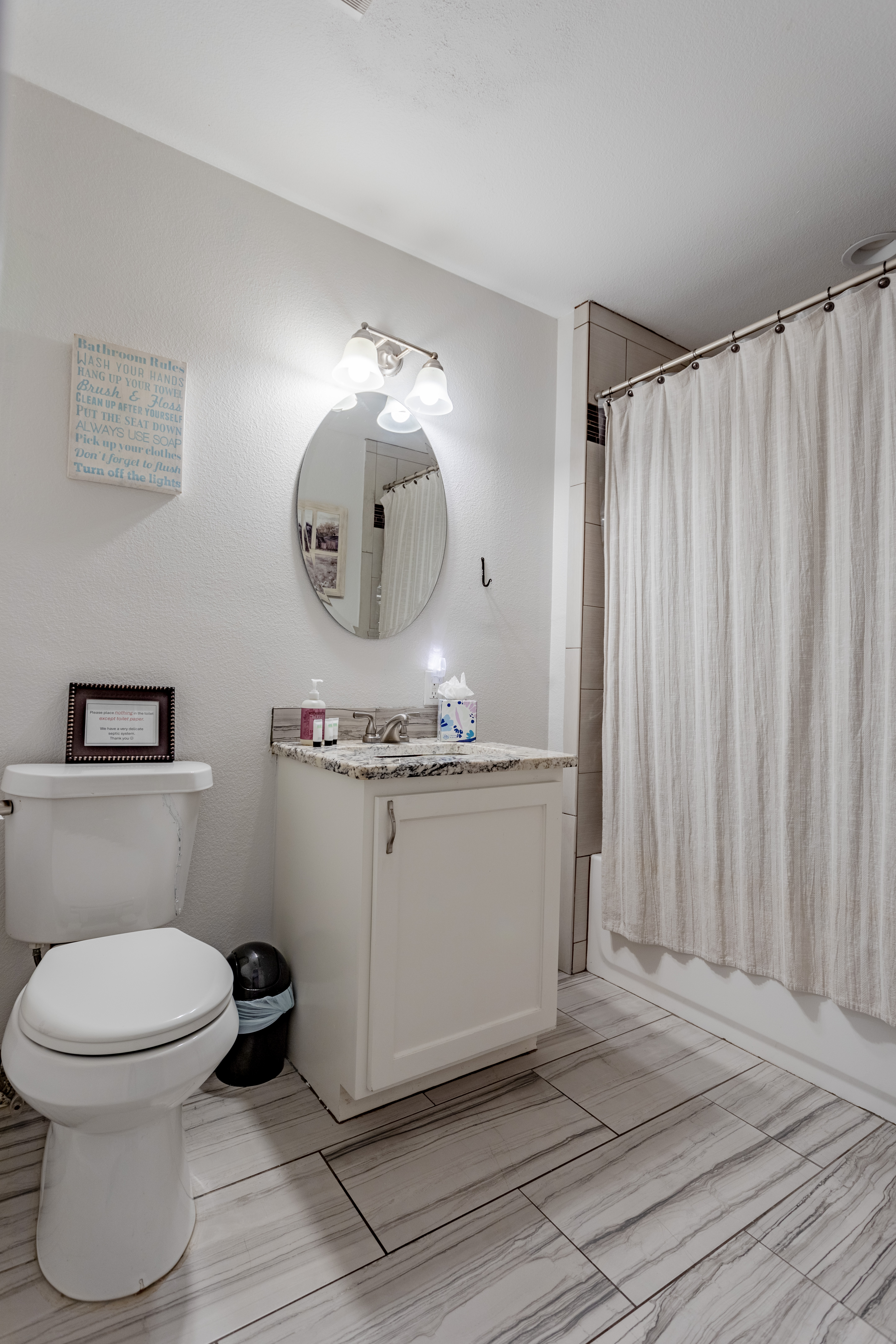 Bright updated bathroom with tiled floors and full tub-shower combo