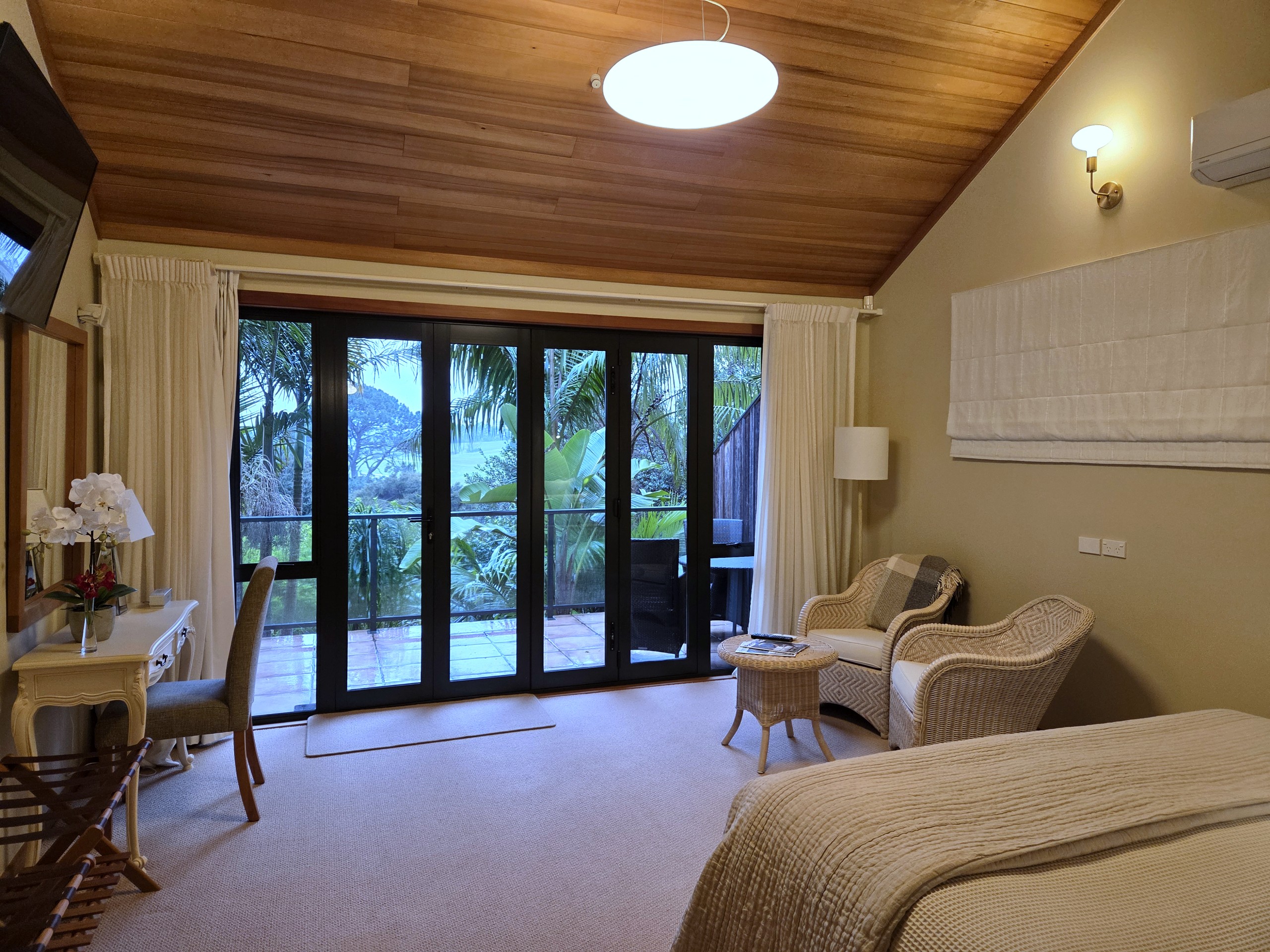 Balcony Super King Suite: super king bed, wicker chairs and bi-fold doors open to the balcony